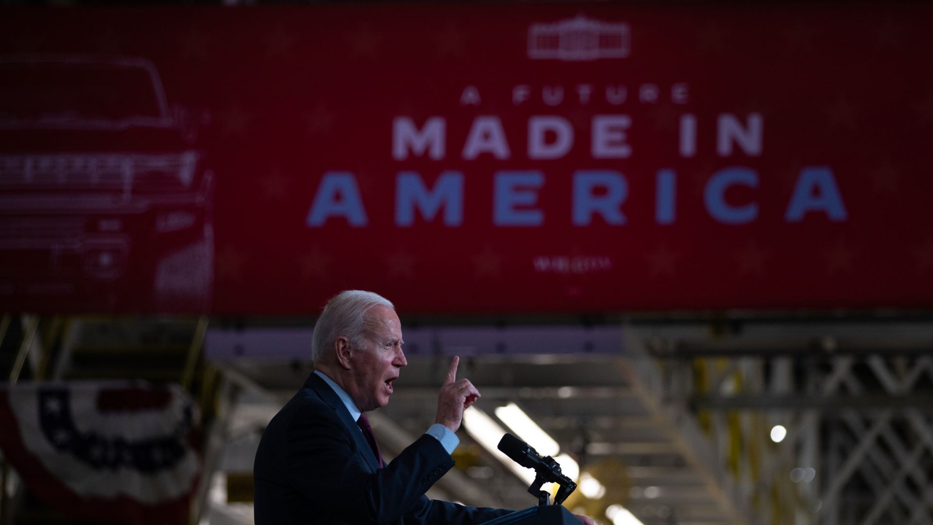 Biden waving his finger in front of a banner