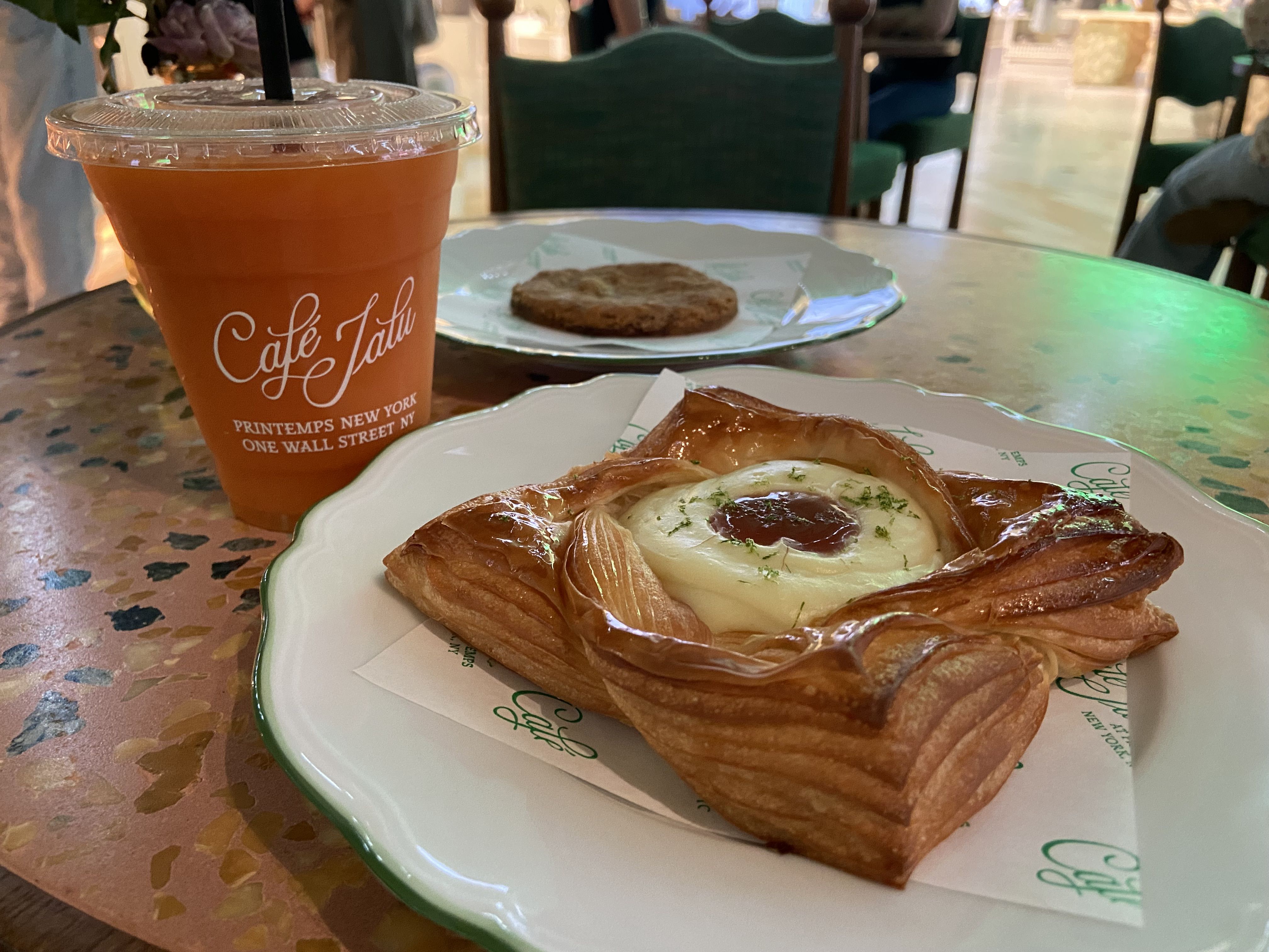 A pastry, a cookie and a fresh juice on a table