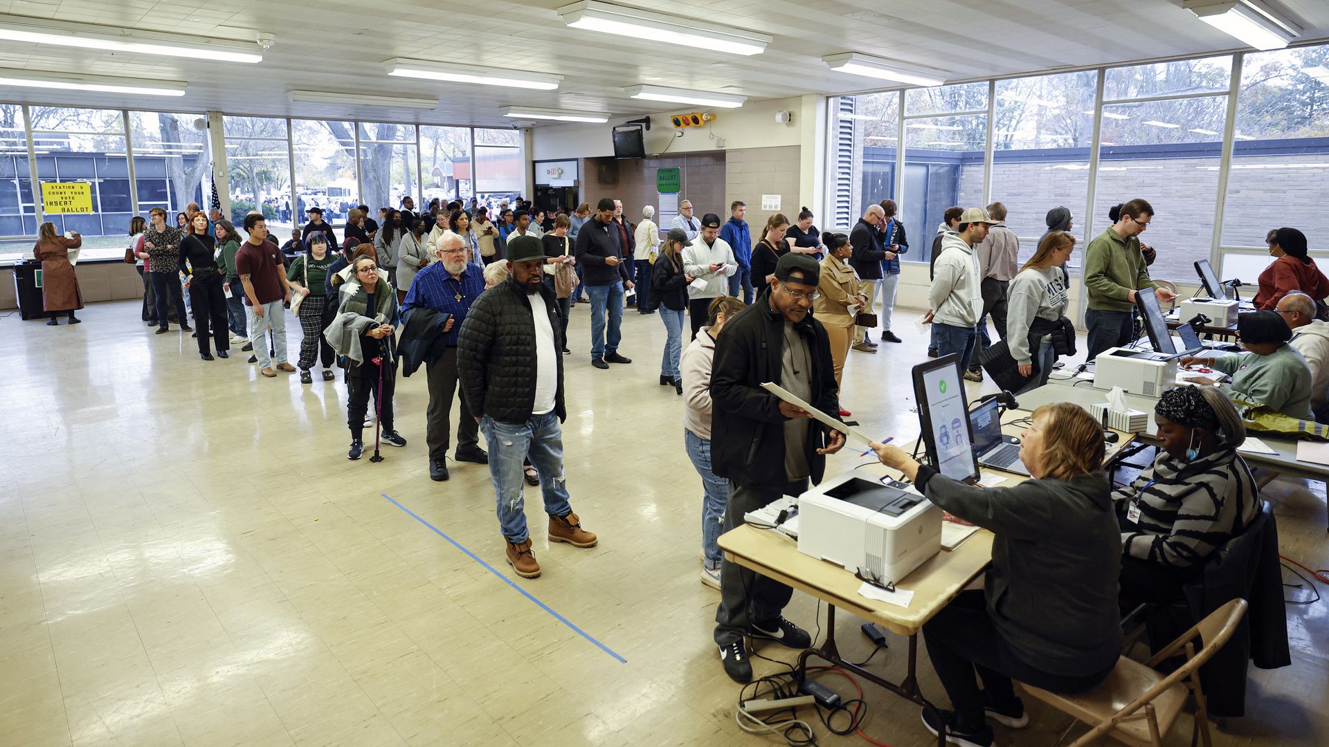 People wait in line to check in during early voting for the US general election at a polling station at Ottawa Hills High School in Grand Rapids, Michigan, on November 3, 2024. (Photo by KAMIL KRZACZYNSKI / AFP) (Photo by KAMIL KRZACZYNSKI/AFP via Getty Images)