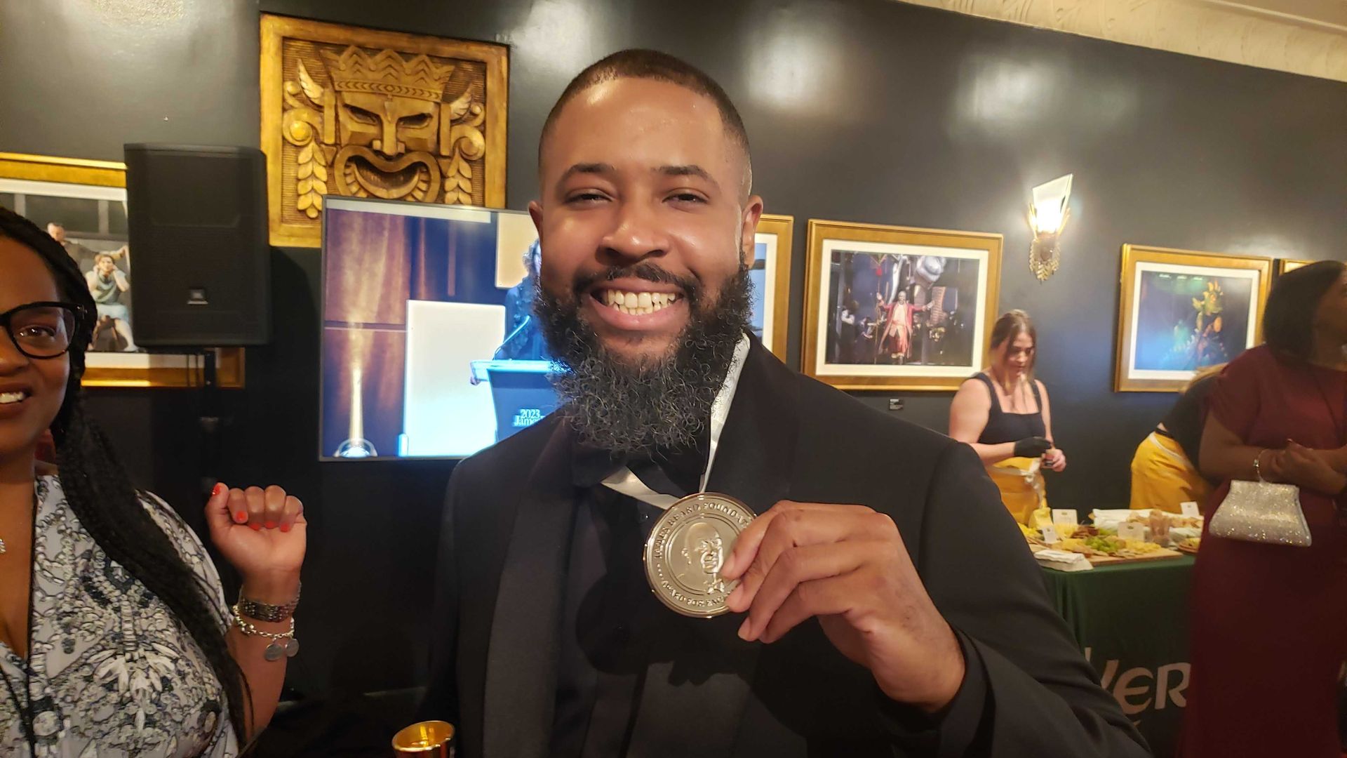 Virtue chef Damarr Brown smiles while holding his James Beard Award