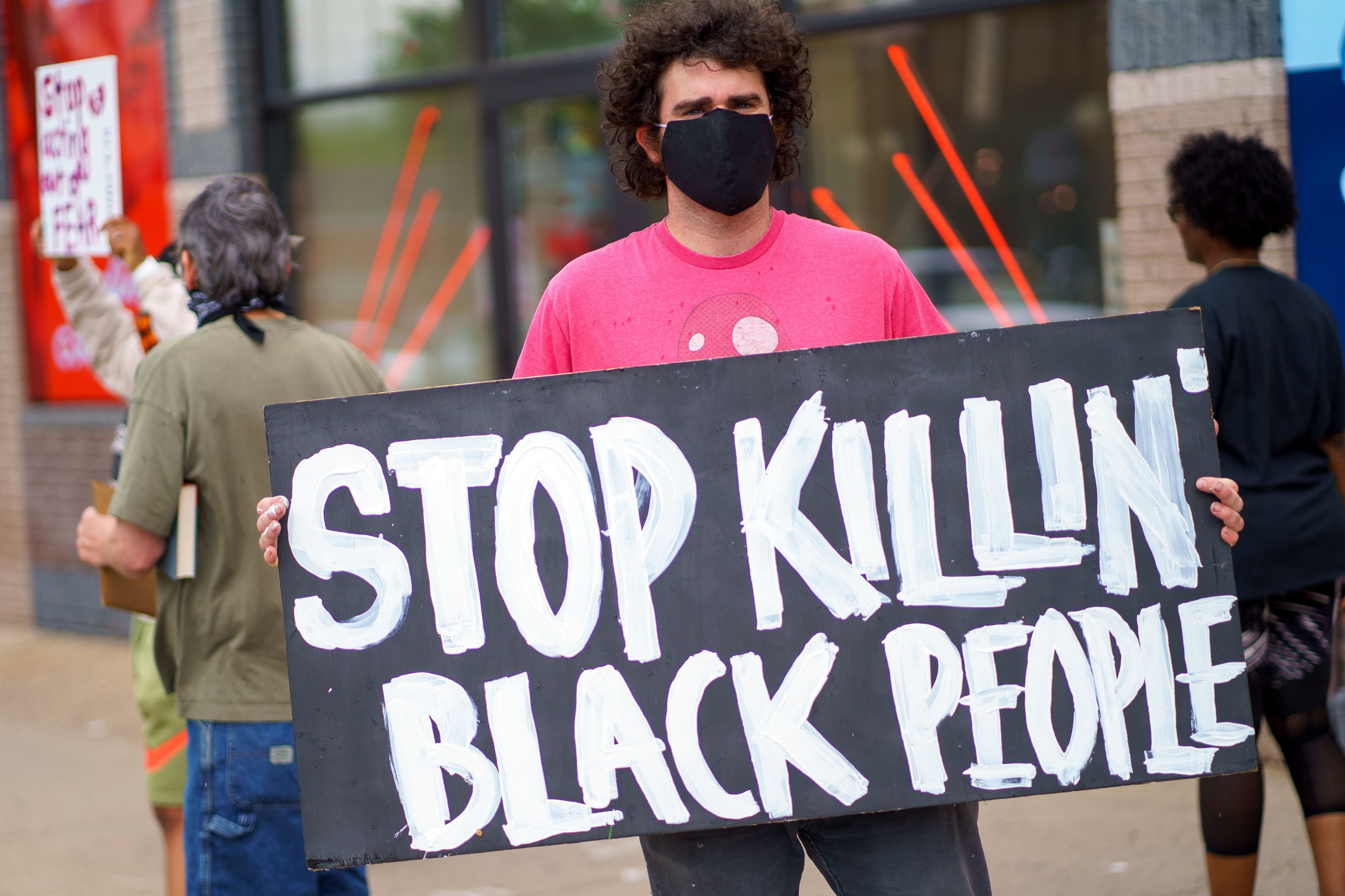 Man holding sign that reads "Stop Killing Black People"