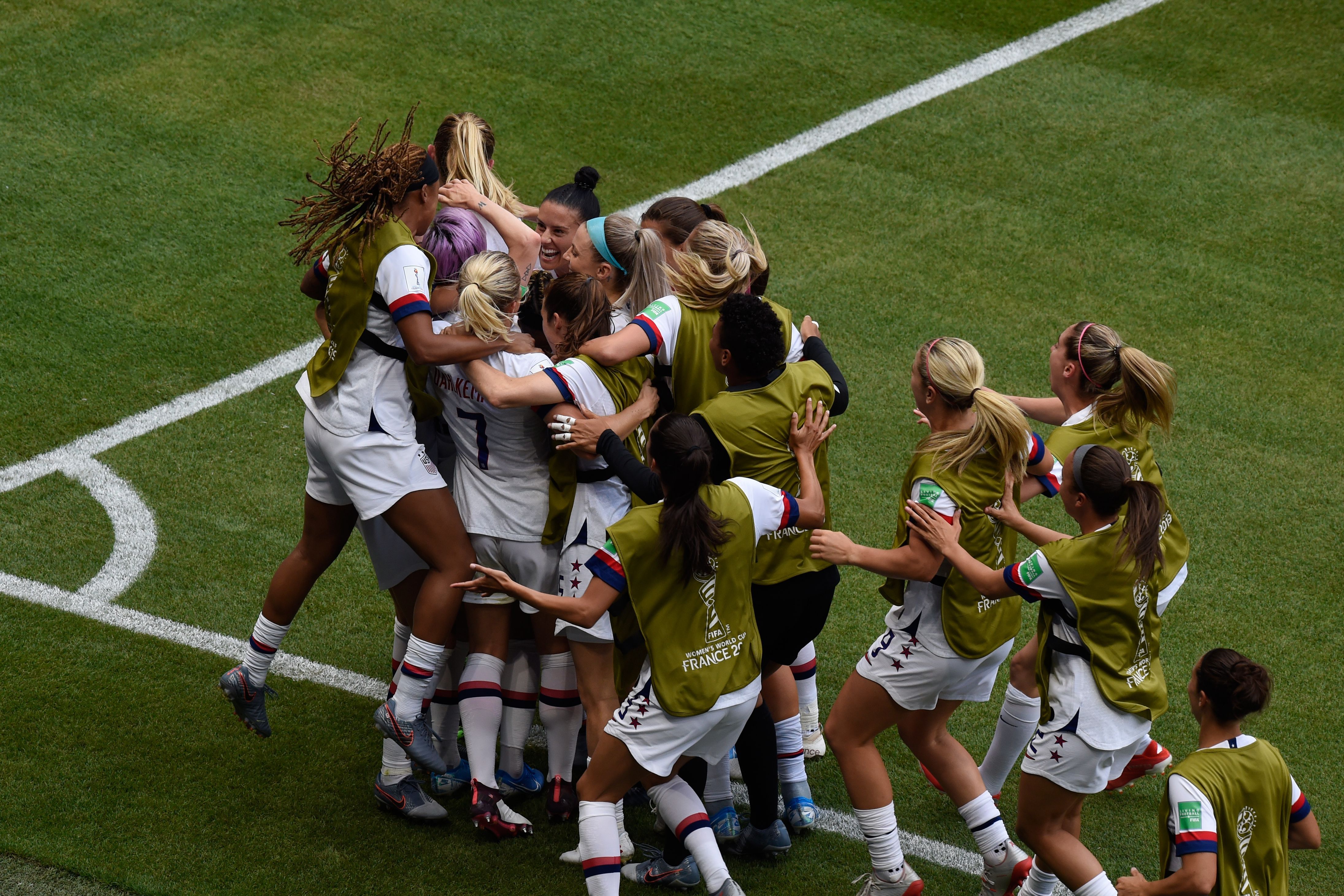 United States' forward Megan Rapinoe is swamped by her teammates after scoring from the penalty spot.
