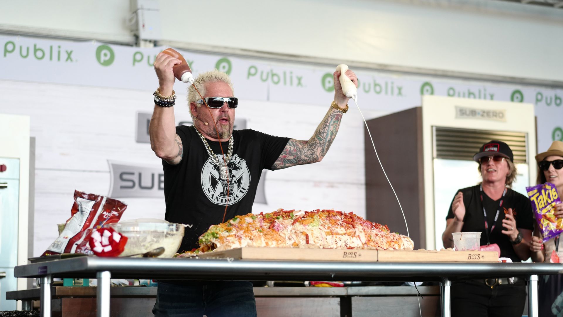 Guy Fieri adds sauce to a giant burrito. 