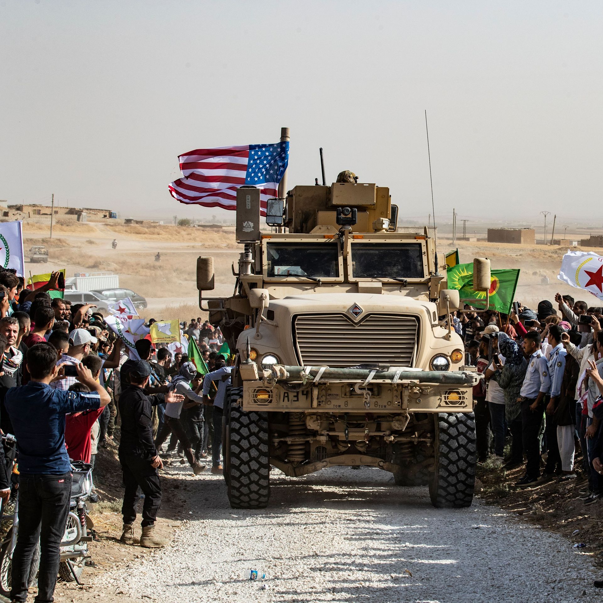 Syrians gather around a U.S. armored car