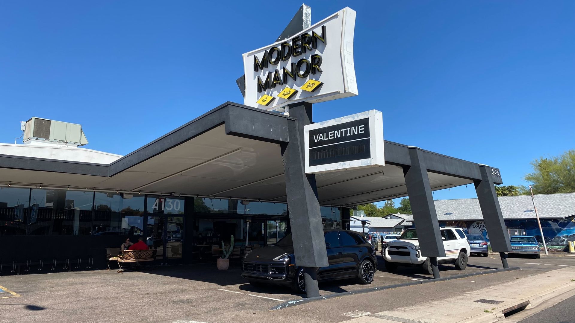 A midcentury modern building with signs that say, "Modern Manor" and "Valentine." 
