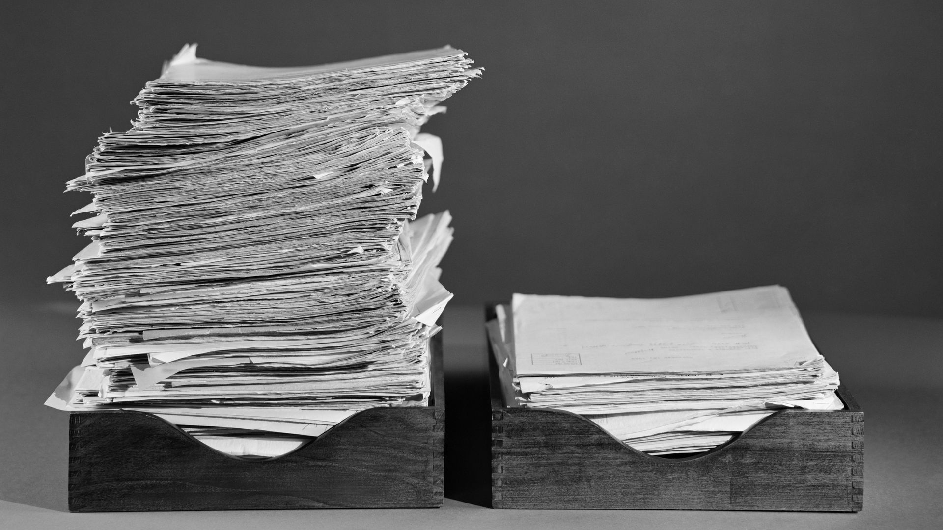 Photo of two boxes, with one containing a bigger stack of papers than the other