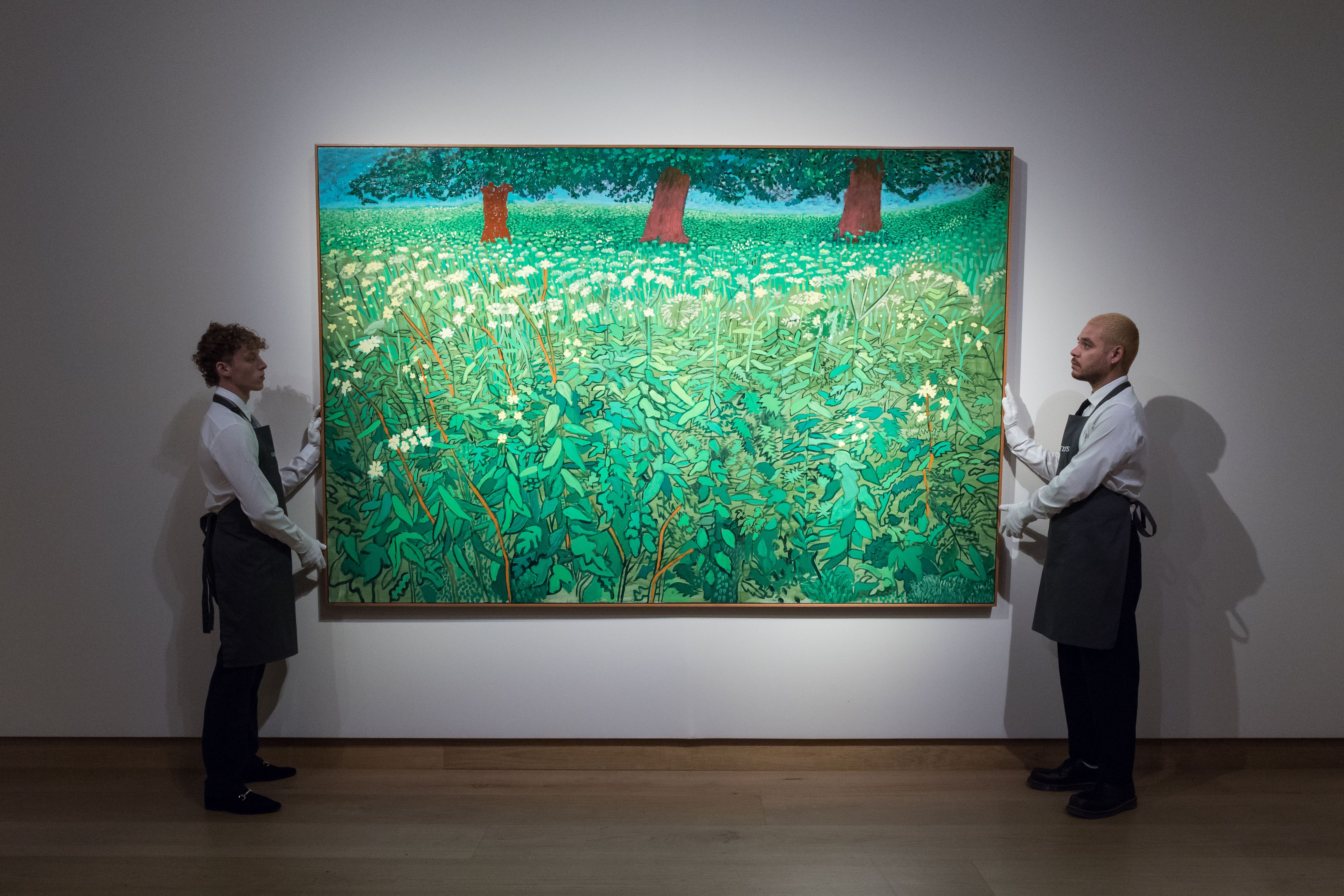  Art handlers hold a painting titled 'Queen Anne's Lace Near Kilham' by David Hockney in London.