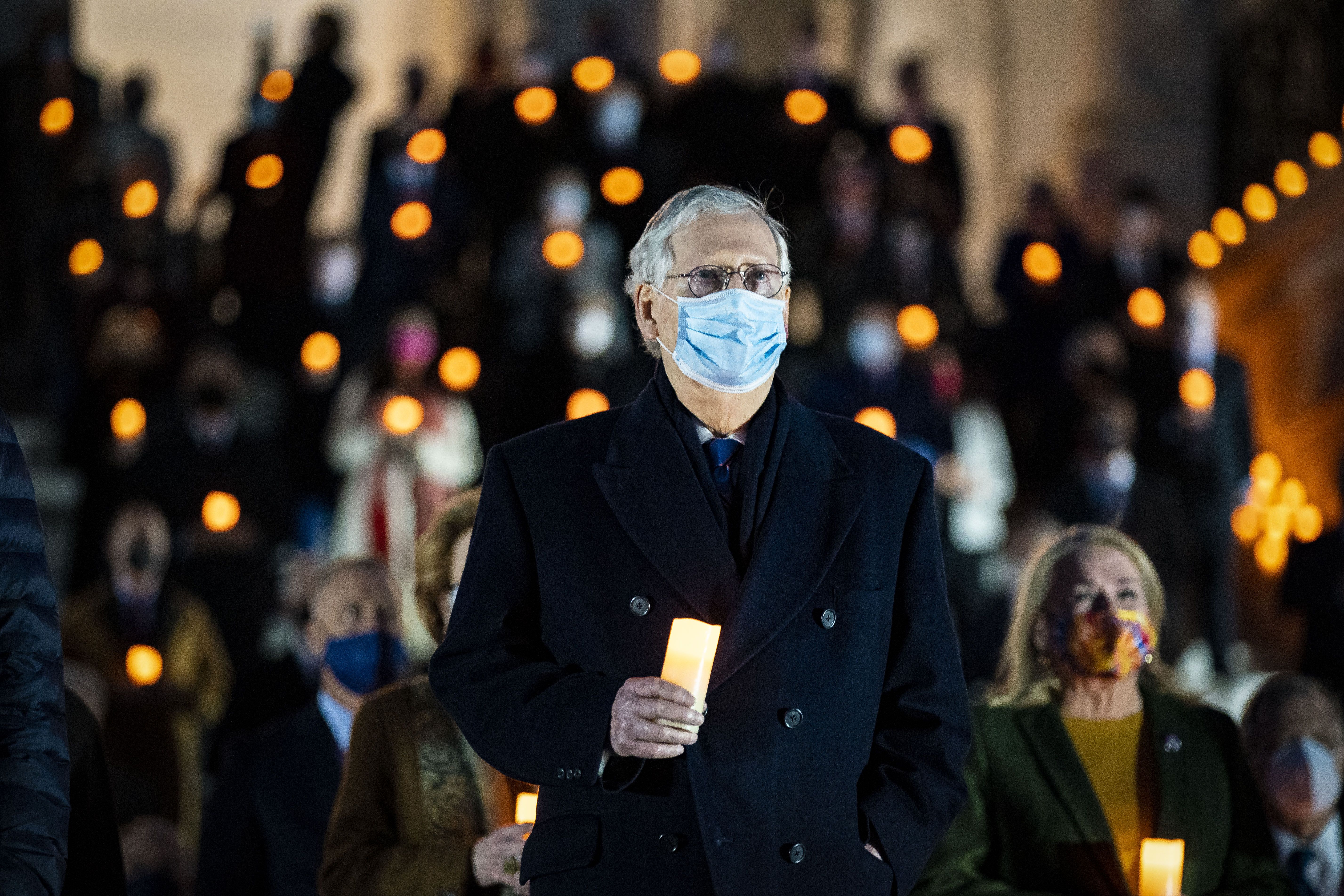 Senate Minority Leader Mitch McConnell holding a candle outside of the Capitol on Feb. 23.