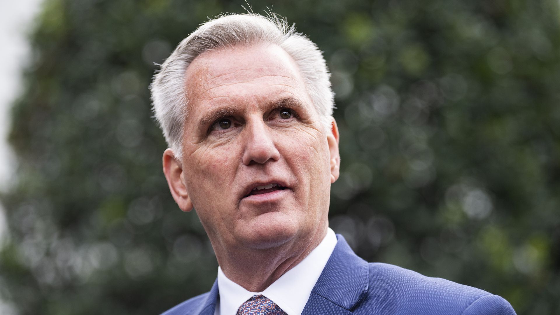 House Minority Leader Kevin McCarthy (R-Calif.), wearing a blue suit, white shirt and purple tie, speaks to reporters outside the White House.
