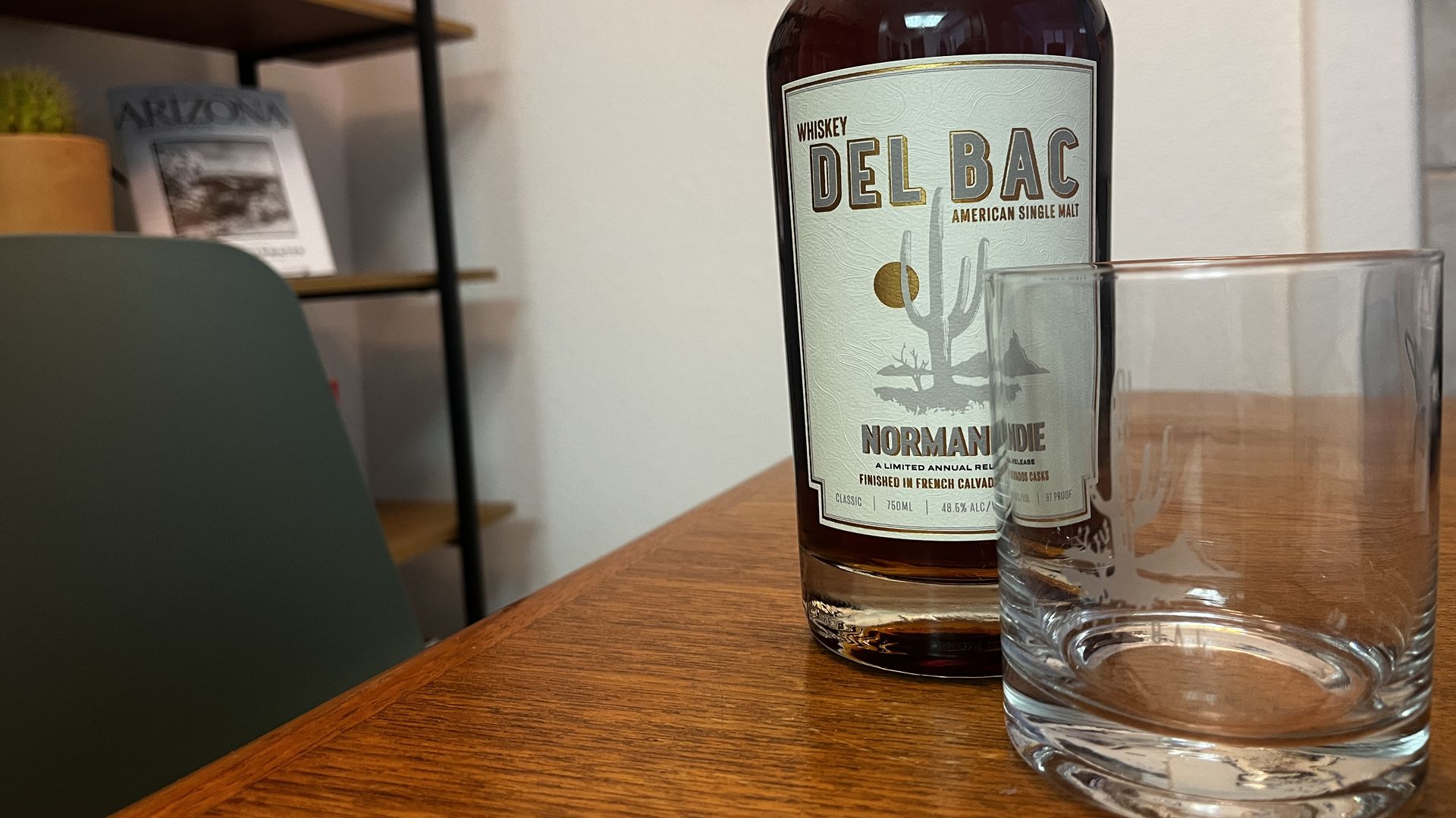 A bottle of Whiskey Del Bac and a cocktail glass with the logo. 