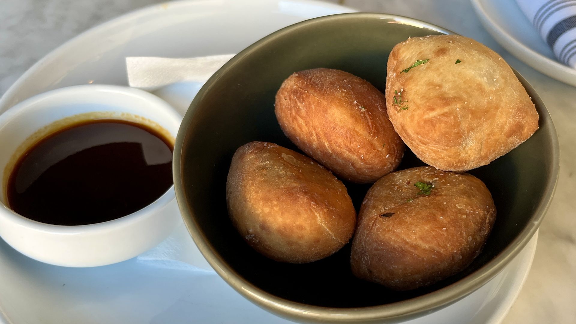 dish of gravy next to doughnuts