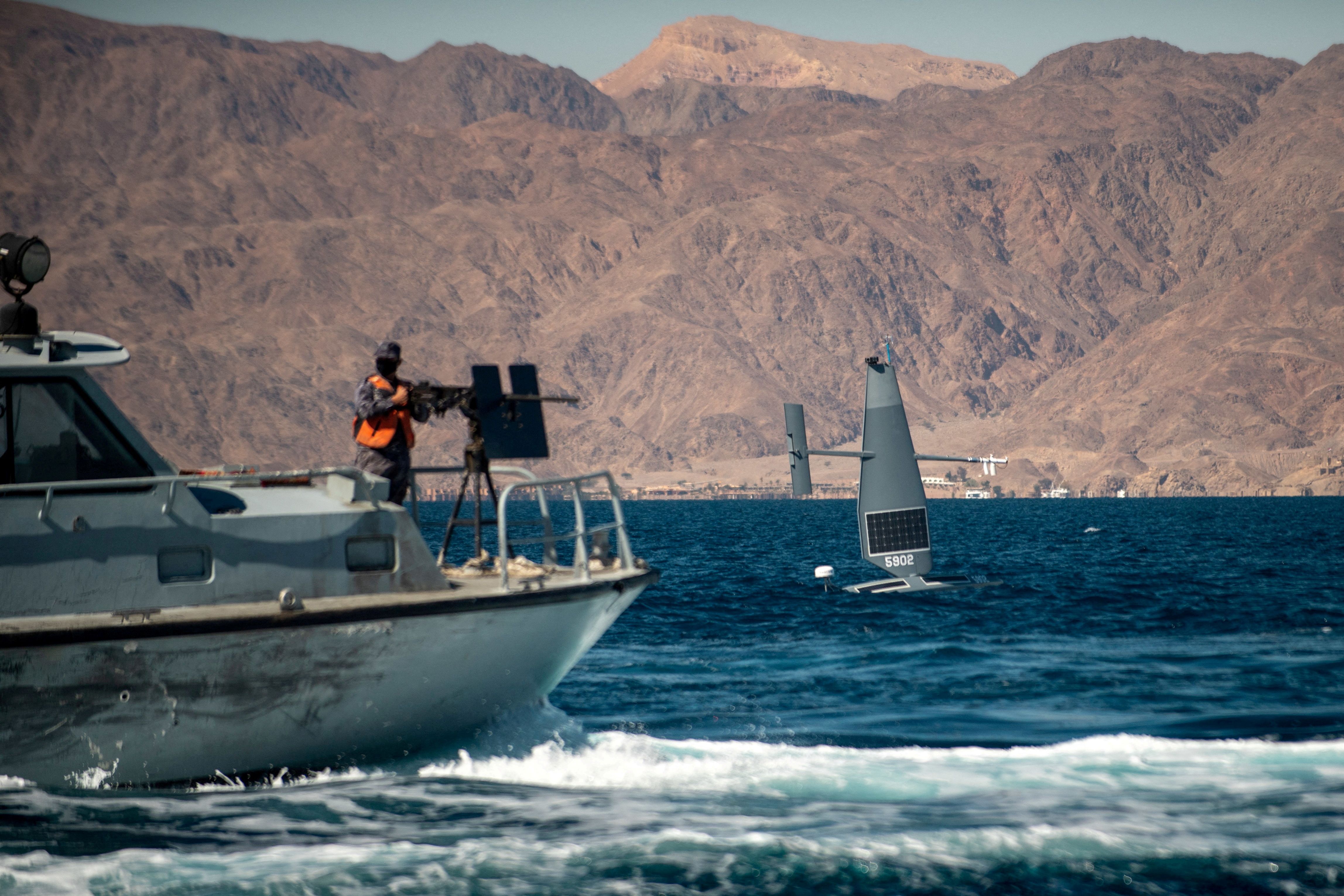 A Saildrone Explorer unmanned surface vessel sails by a Royal Jordanian Navy patrol craft during a joint exercise with U.S. forces.