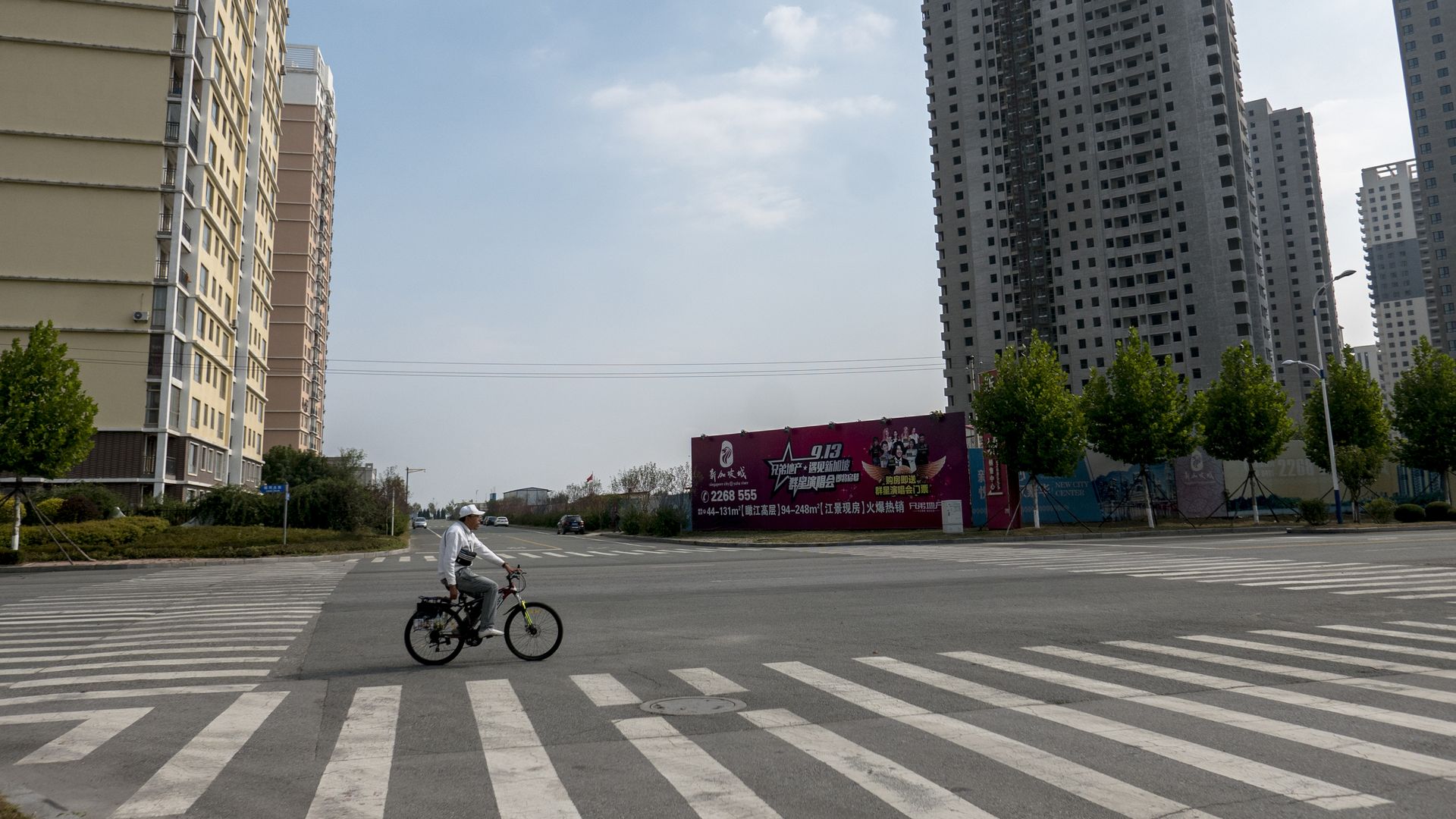 A man rides a bike through an empty city