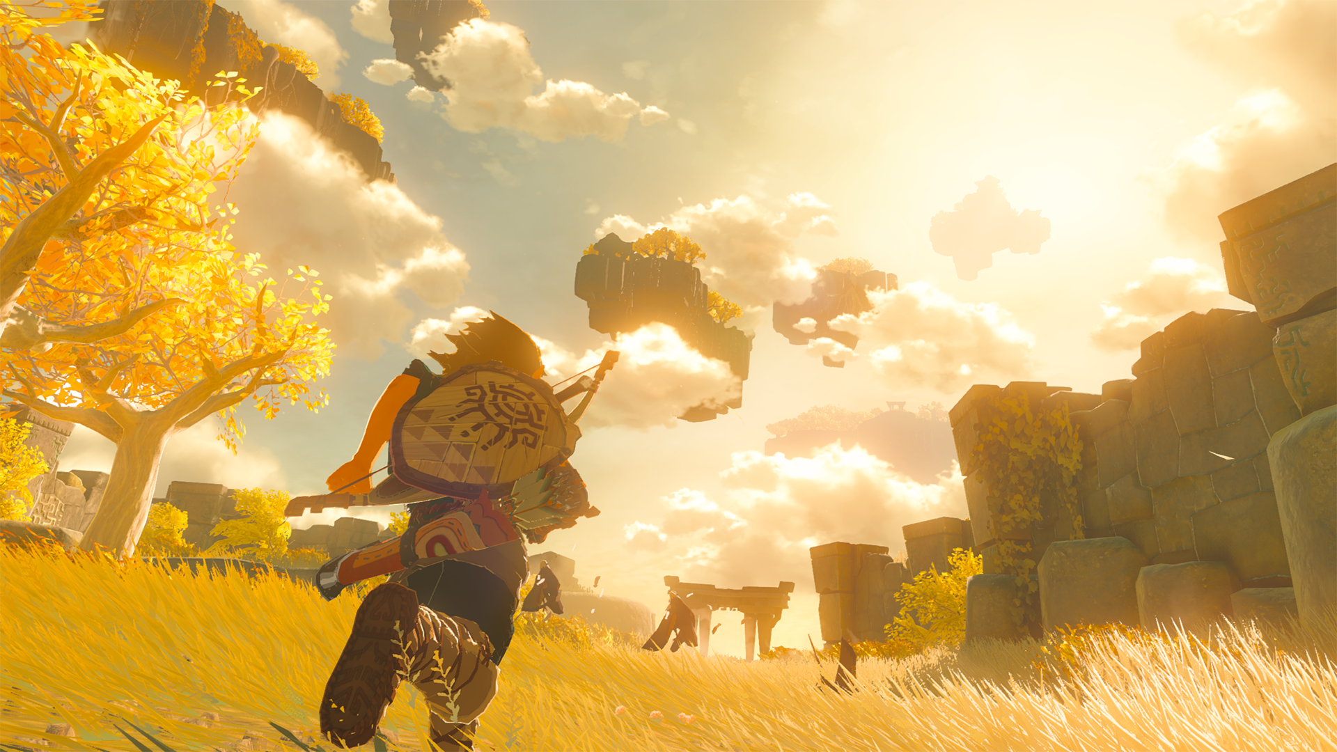 Video game screenshot of a young man with a shield on his back running through tall grass below a golden sky