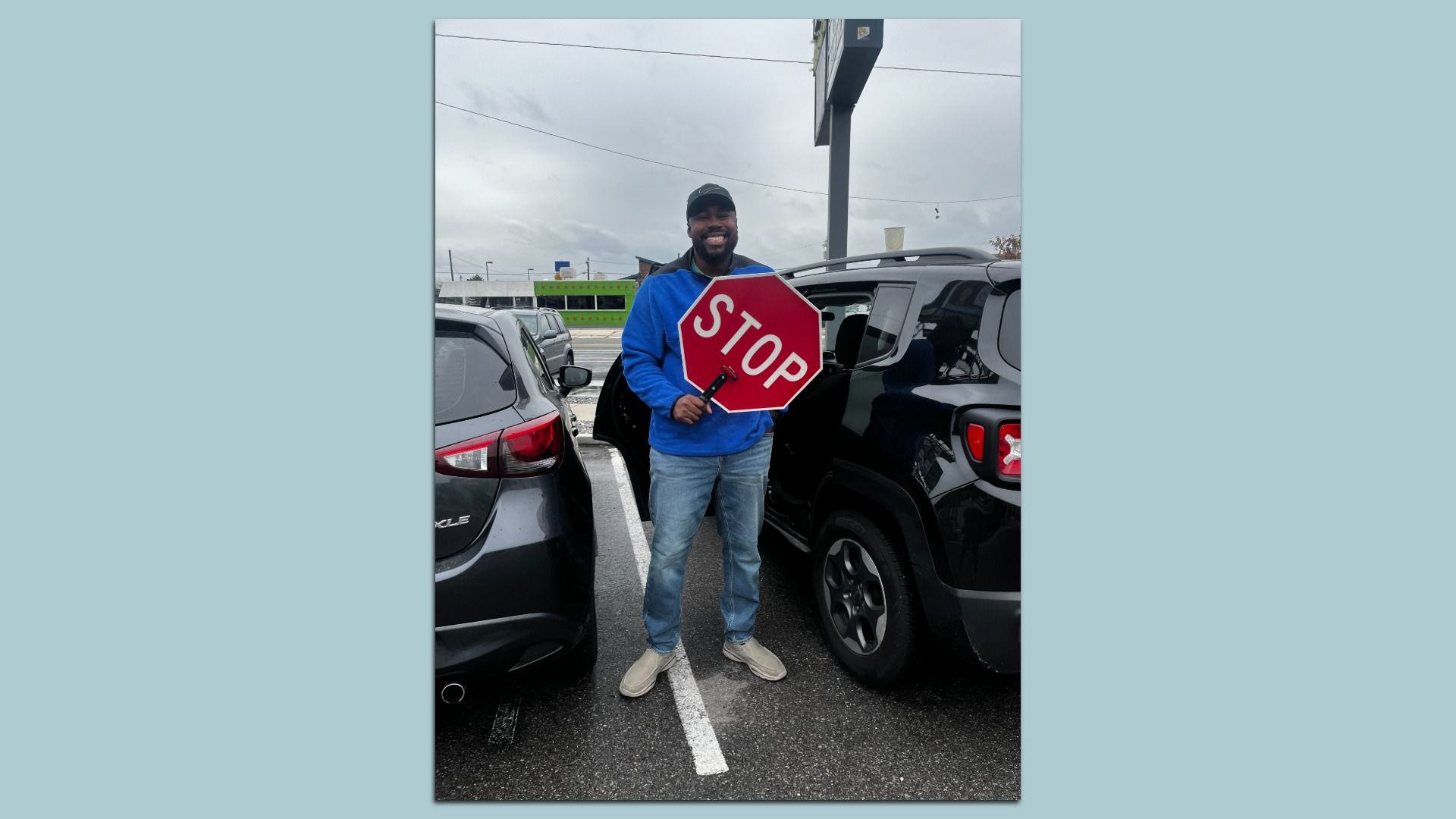 A man holds a red stop sign. 