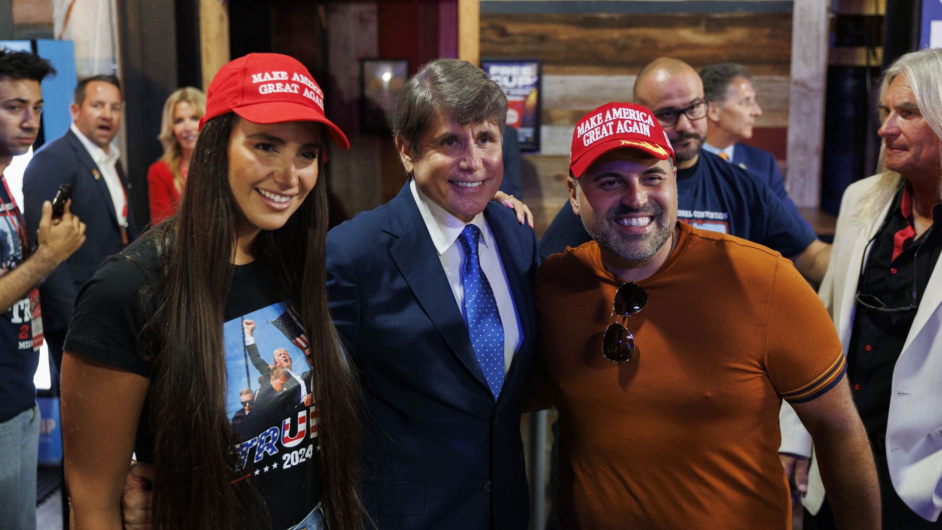 Blagojevich between people with MAGA hats