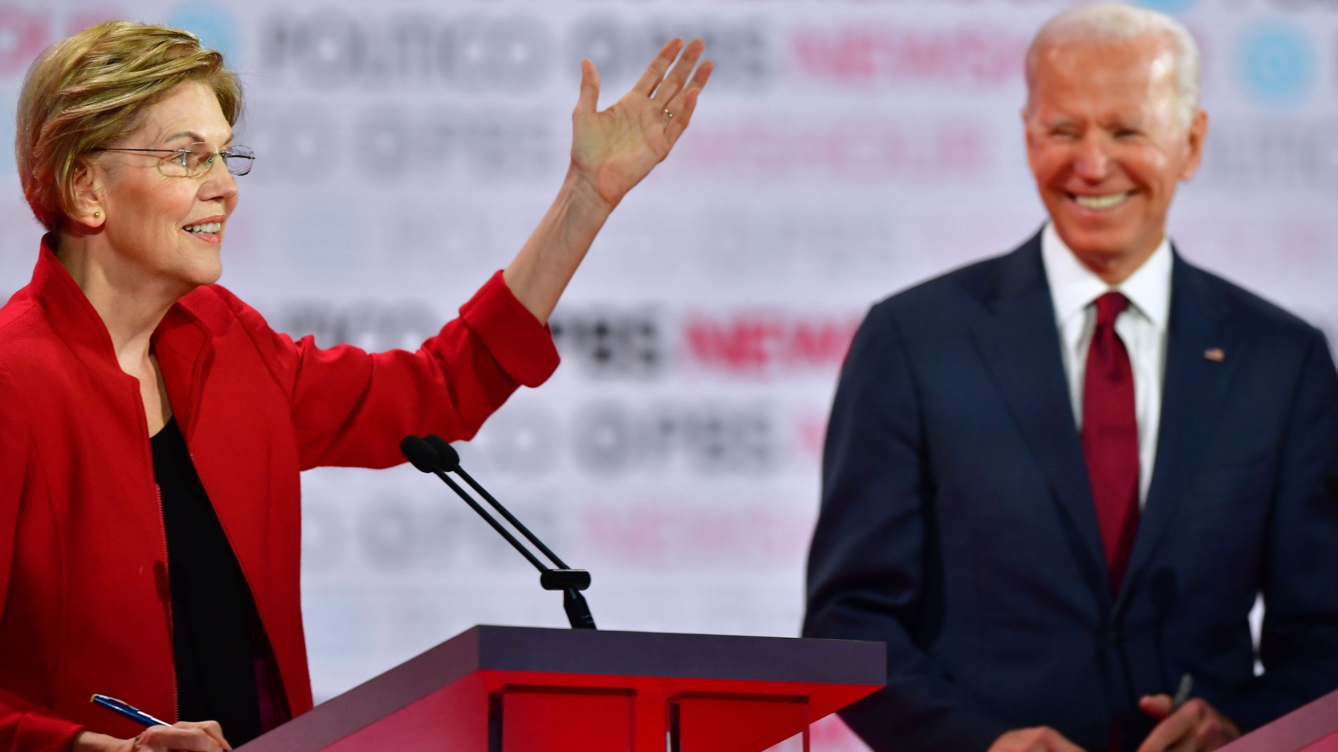 In this image, Elizabeth Warren and Joe Biden stand on stage