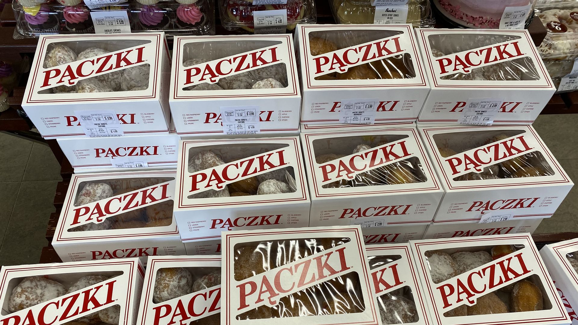 rows of boxes with pastries that say, "paczki."