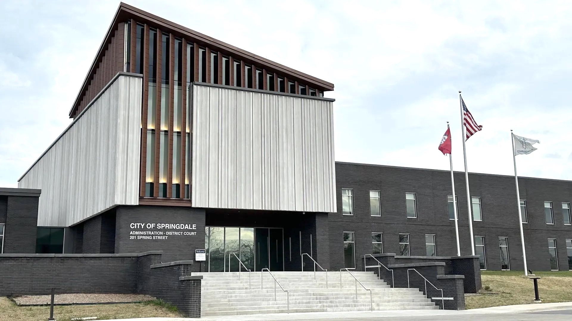 Modern black-and-white building with flags and steps, labeled “City of Springdale Administration – District Court.”