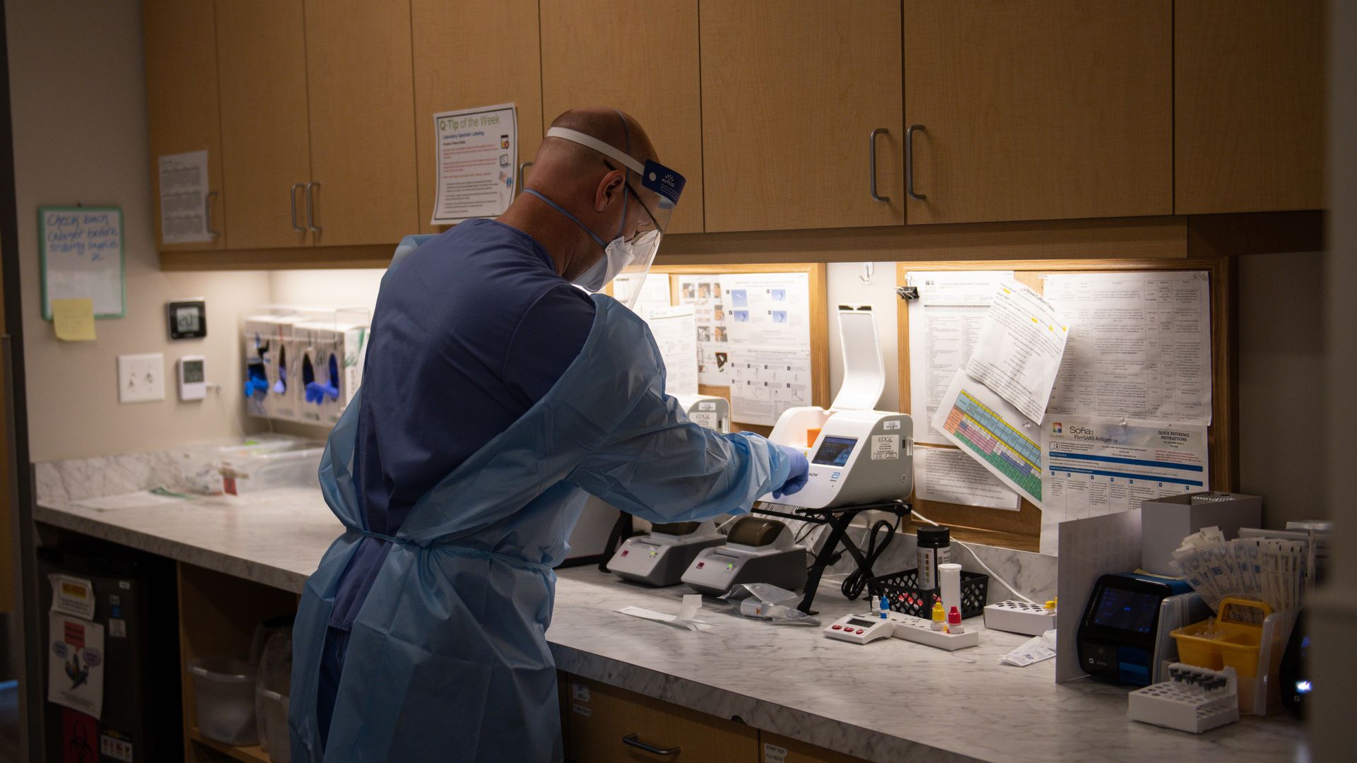 A healthcare worker inserts a Covid-19 rapid test into a machine