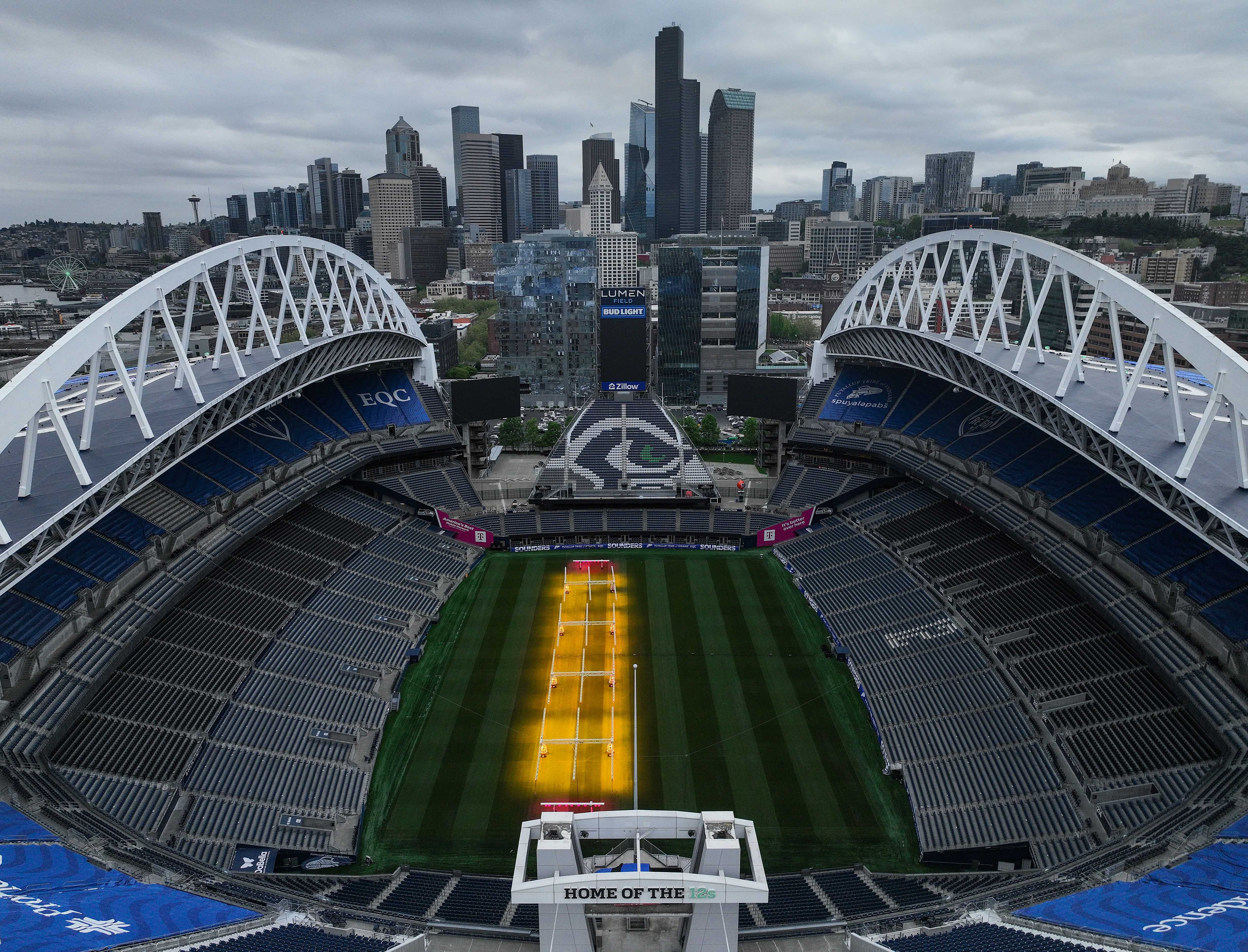Lumen Field is shown from above with grow lamps on part of the pitch, with the Seattle skyline in the background.