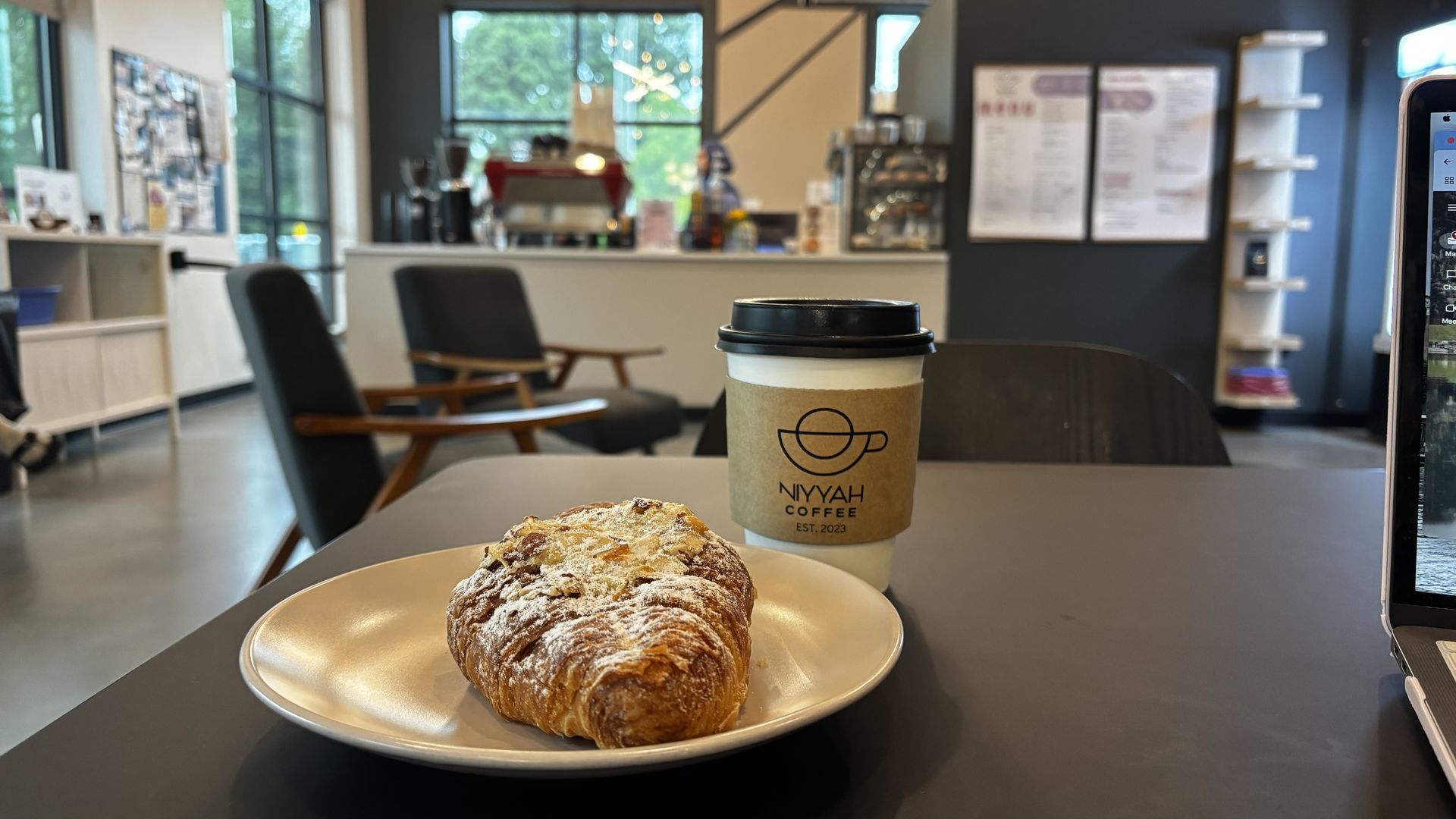A croissant and a coffee on a table. 