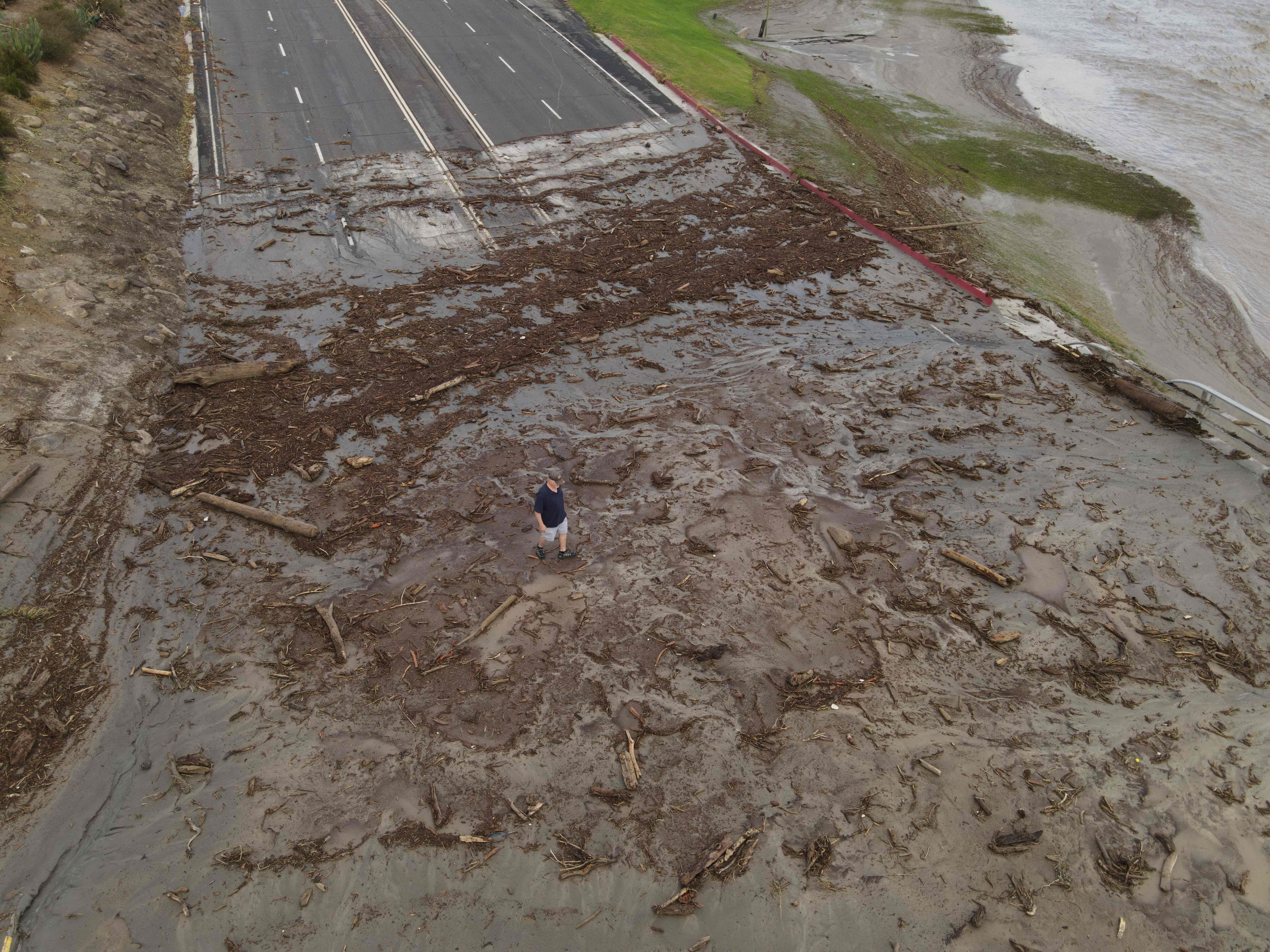 An aerial image shows a man surveying debris following heavy rains from Tropical Storm Hilary, at Thurderbird Country Club in Rancho Mirage, California.