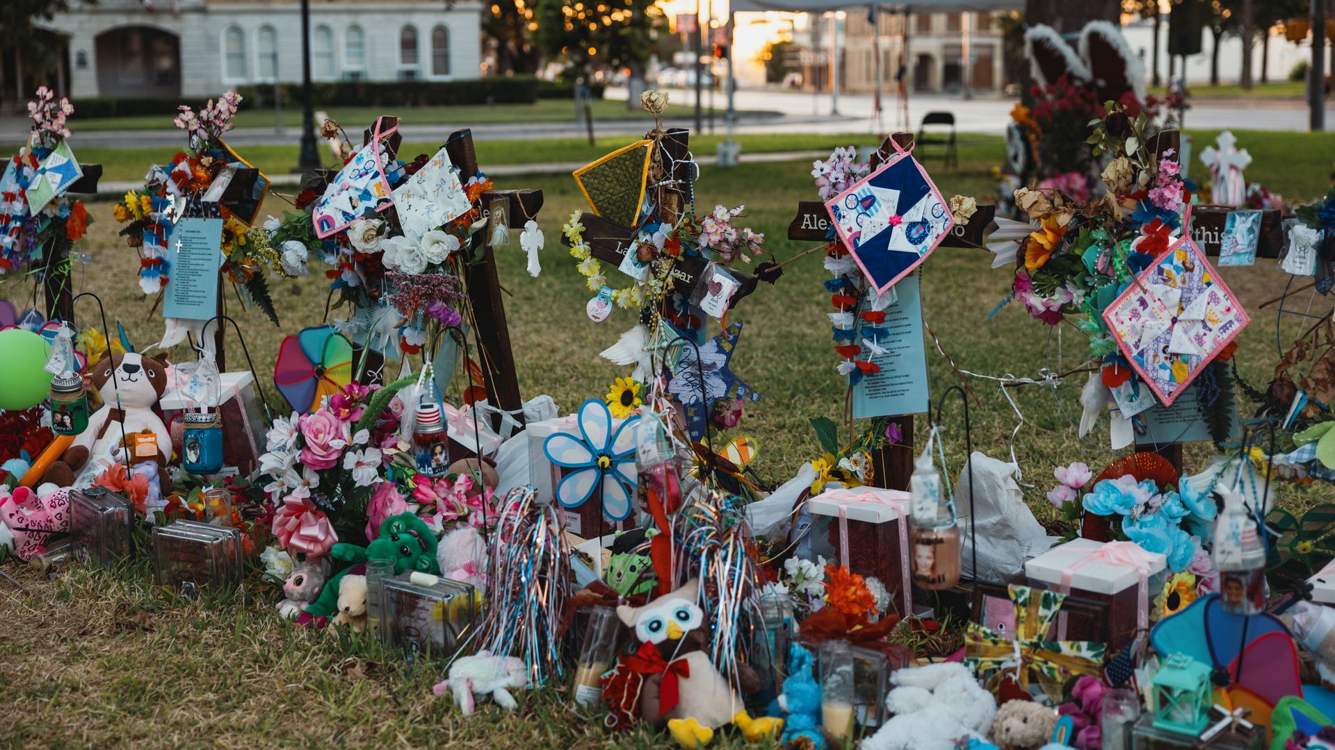 Crosses are decorated with flowers and stuffed animals at a memorial for the victims of the mass shooting at Robb Elementary School