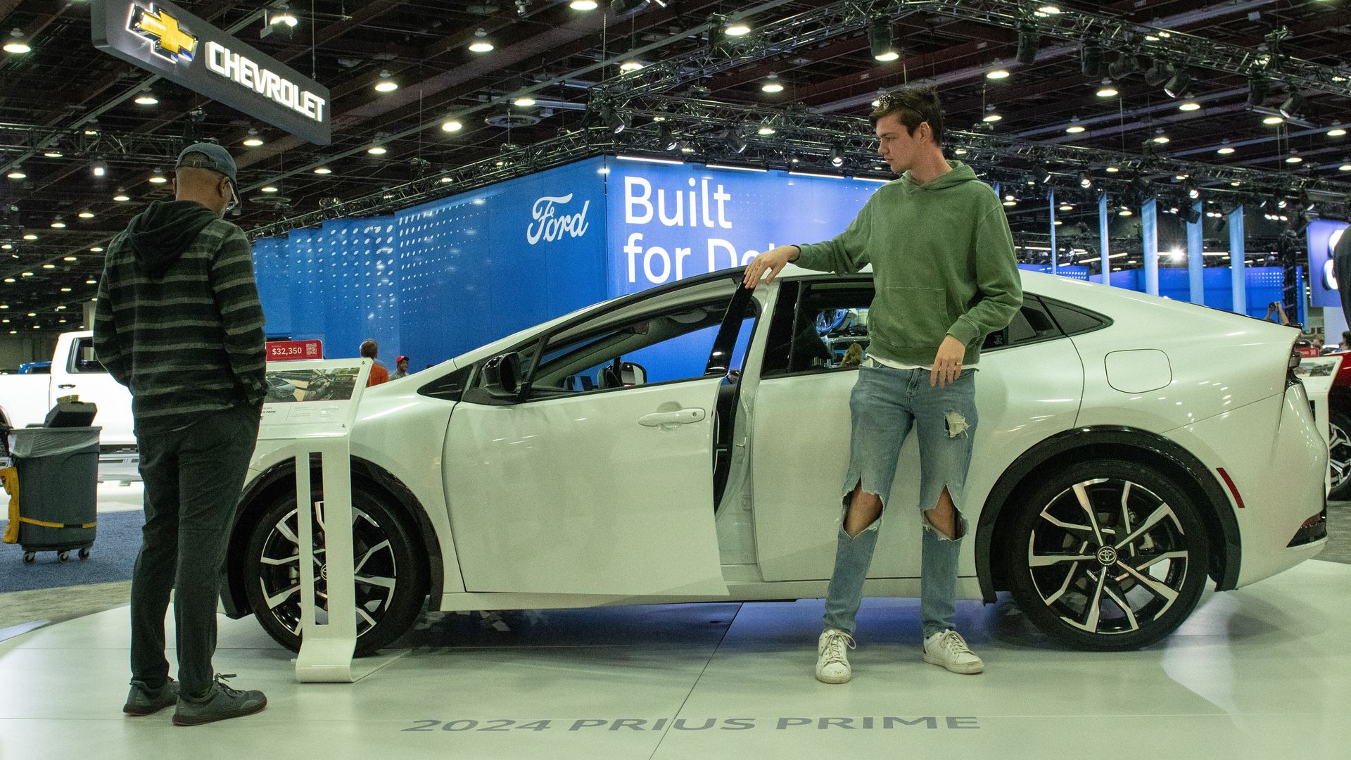 People looking at a 2024 Toyota Prius Prime at a car show in Detroit in September 2023.