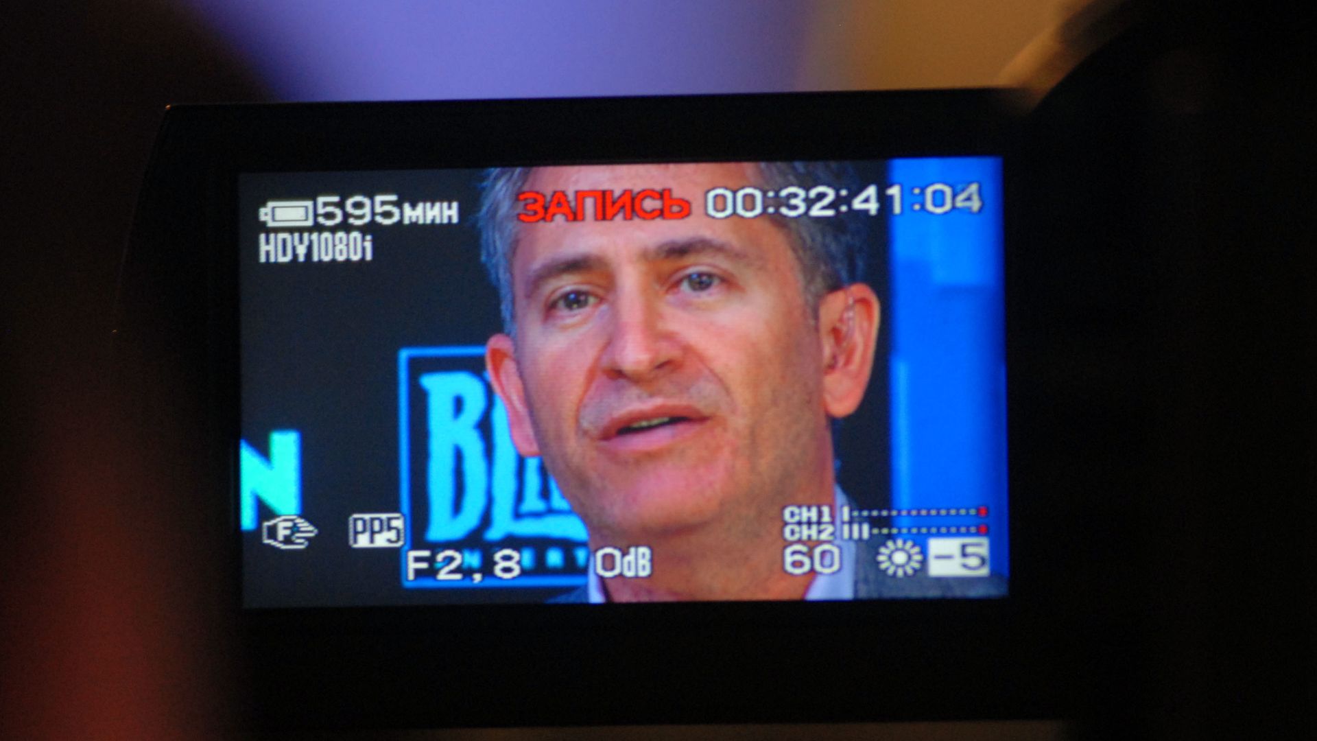 Photo of executive Mike Morhaime, seen through a video camera's viewfinder