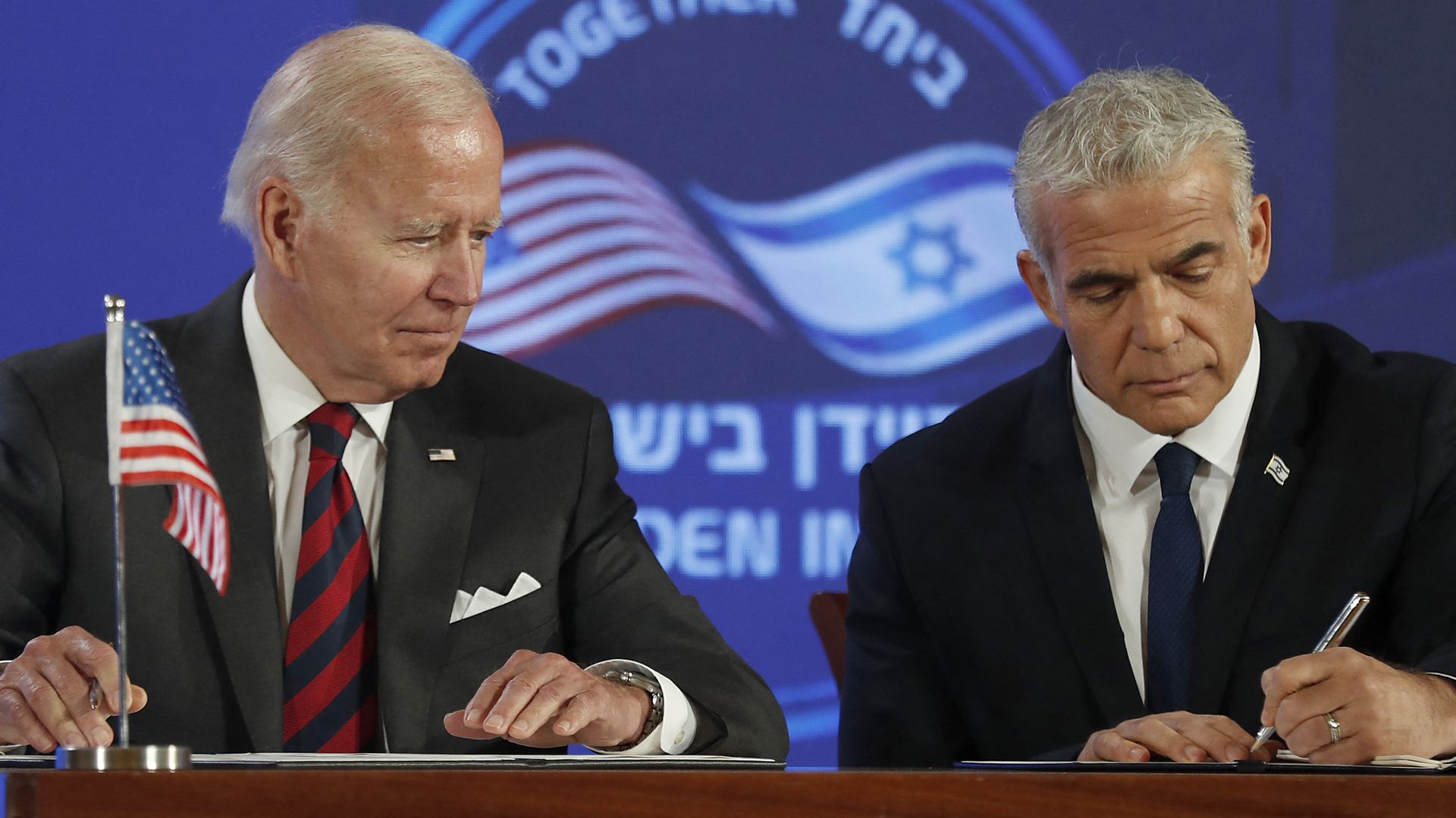 Biden (L) and Israel's caretaker Prime Minister Yair Lapid, sign a security pledge in Jerusalem, on July 14, 2022. 