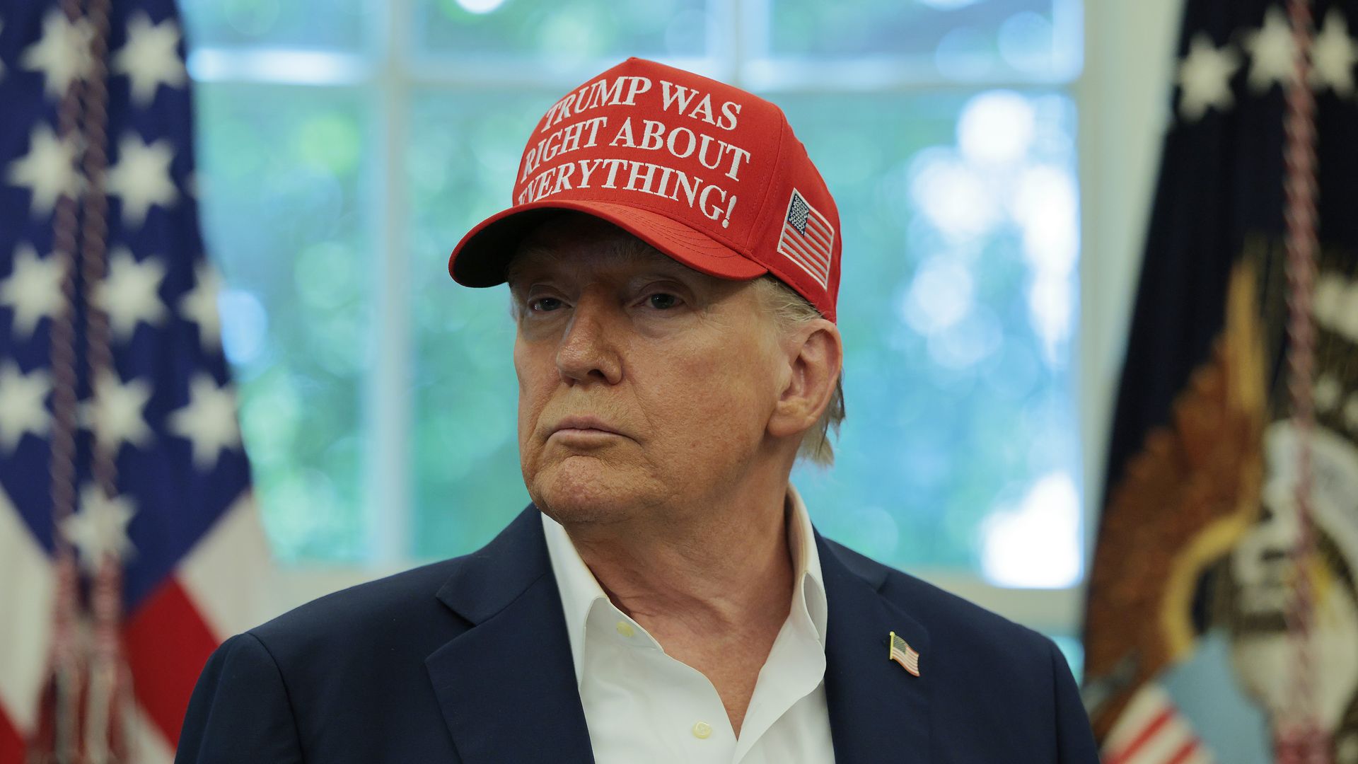 Donald Trump wearing a red hat that says "TRUMP WAS RIGHT ABOUT EVERYTHING!" 