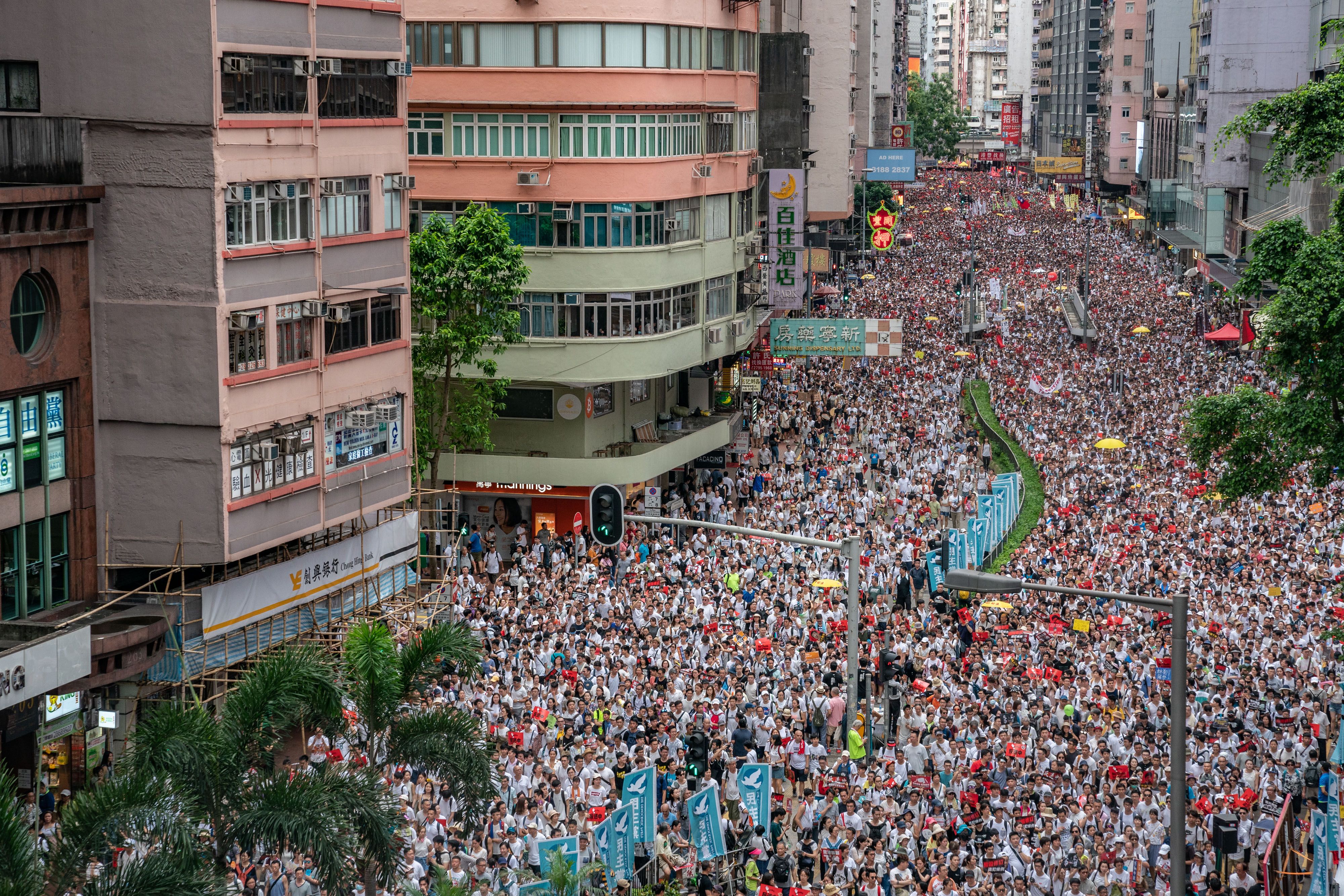 Protesters march on a street during a rally against a controversial extradition law proposal