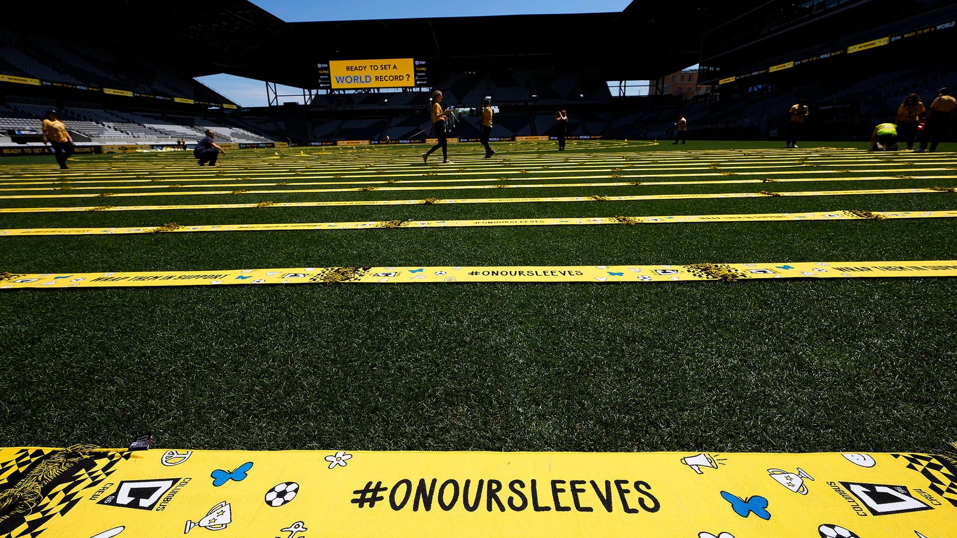 Rows of scarves on the Lower.com Field pitch, with #OnOurSleeves in the foreground