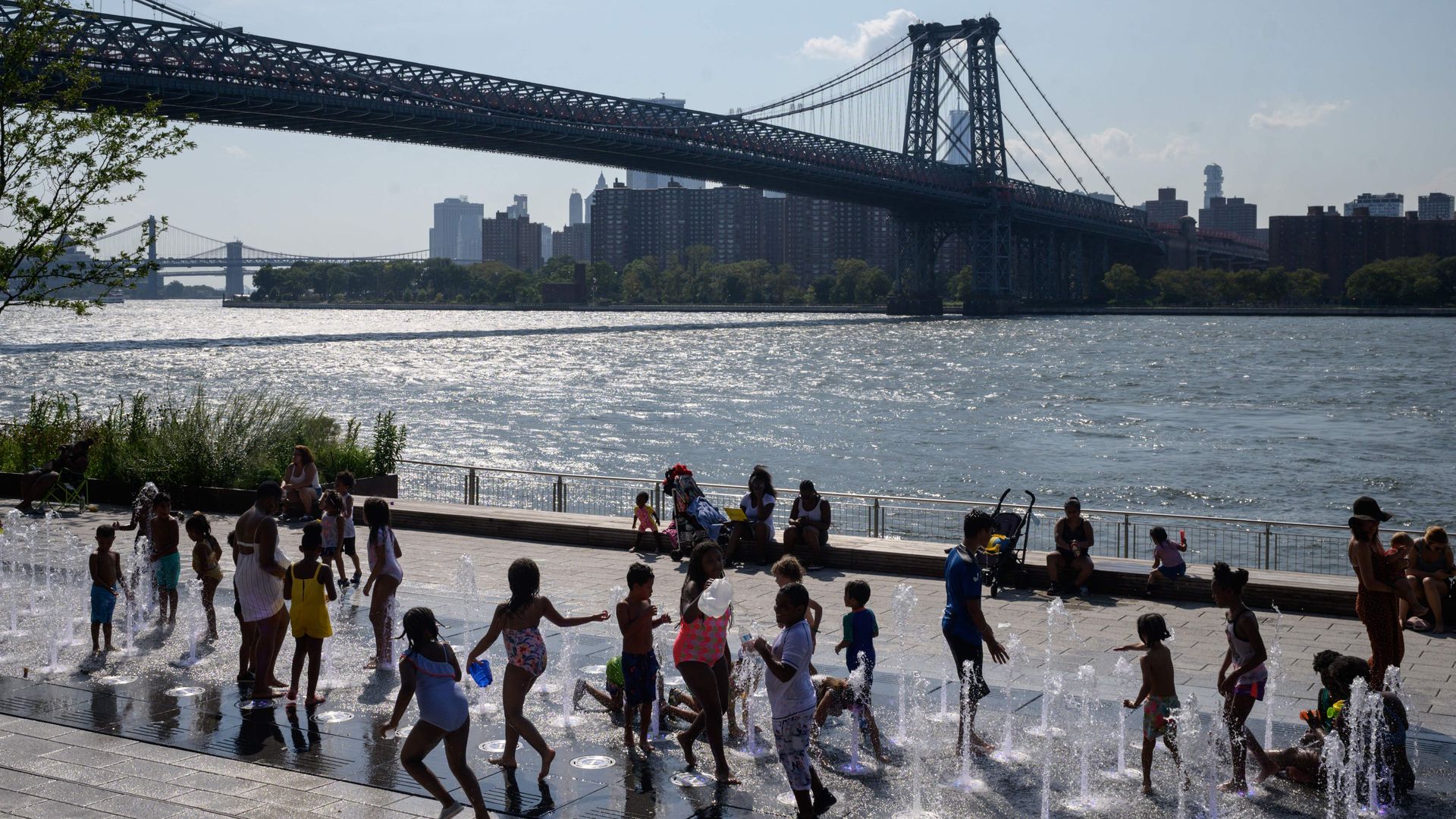 Children play in outdoor fountains in Brooklyn on an excessively hot day in August.