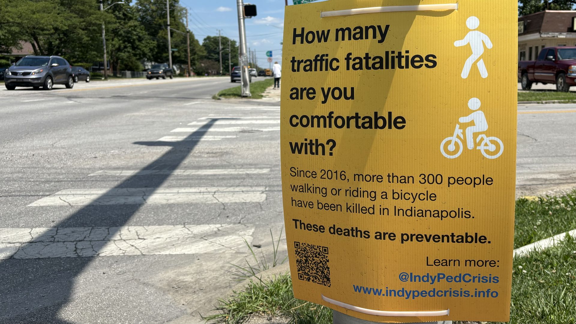 A sign talking about traffic fatalities near a road.