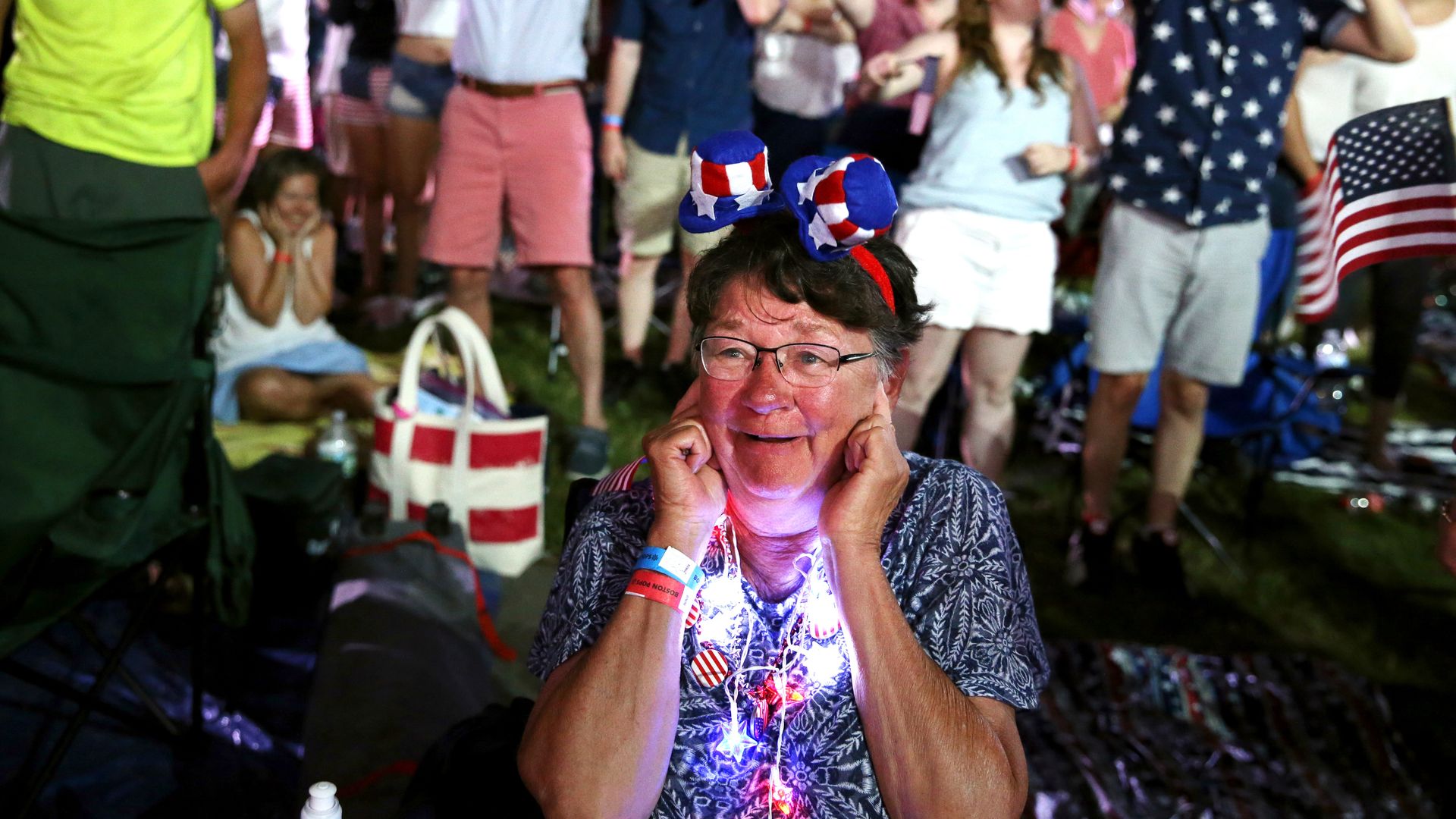 A woman plugs her ears during cannon fire as the Boston Pops plays Tchaikovsky's "1812 Overture"