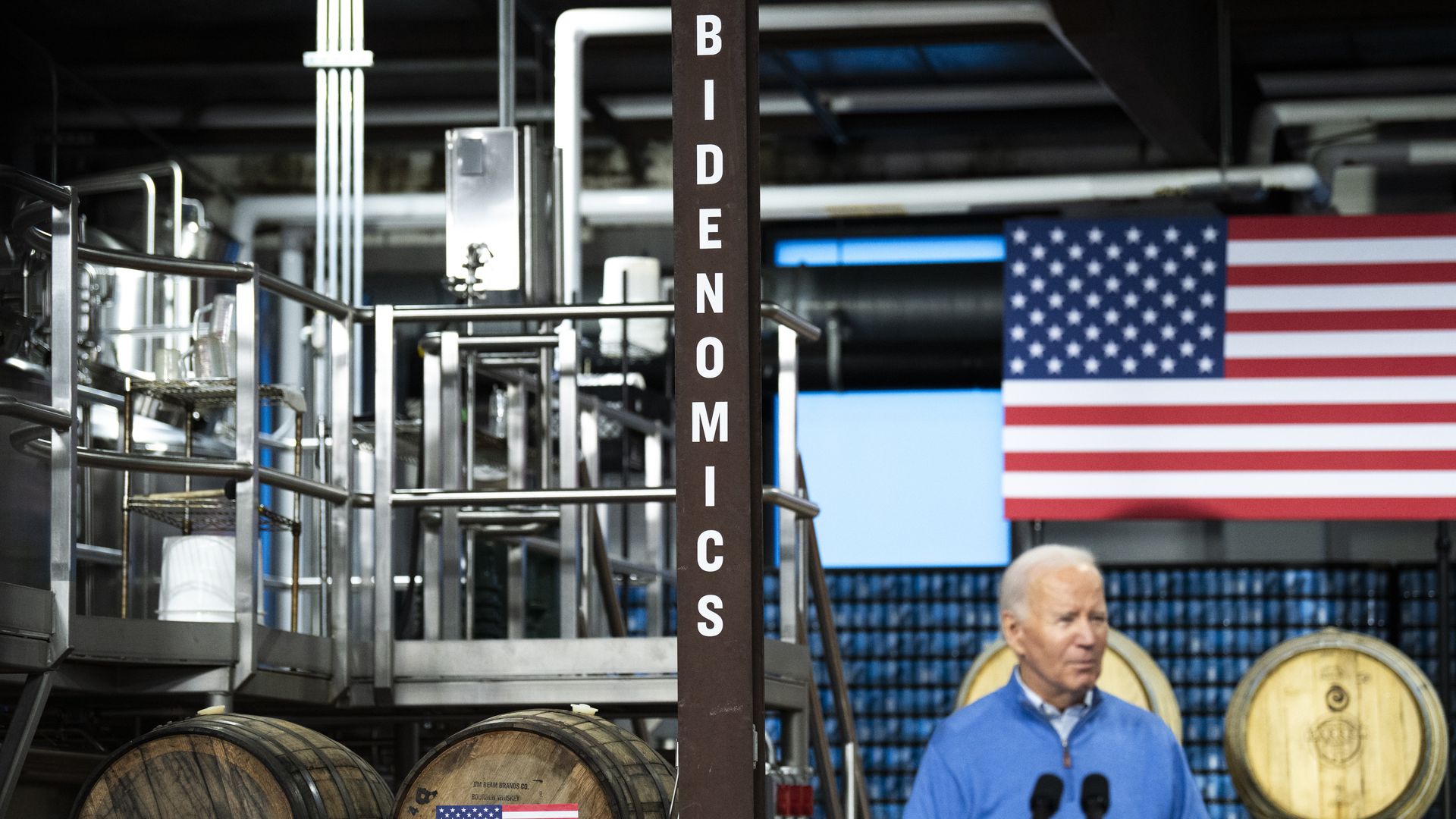 Biden in front of Bidenomics sign