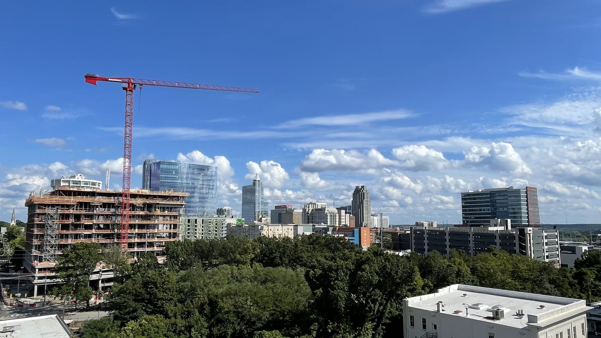 The downtown Raleigh skyline, with a red crane in the foreground on an uncompleted building. 
