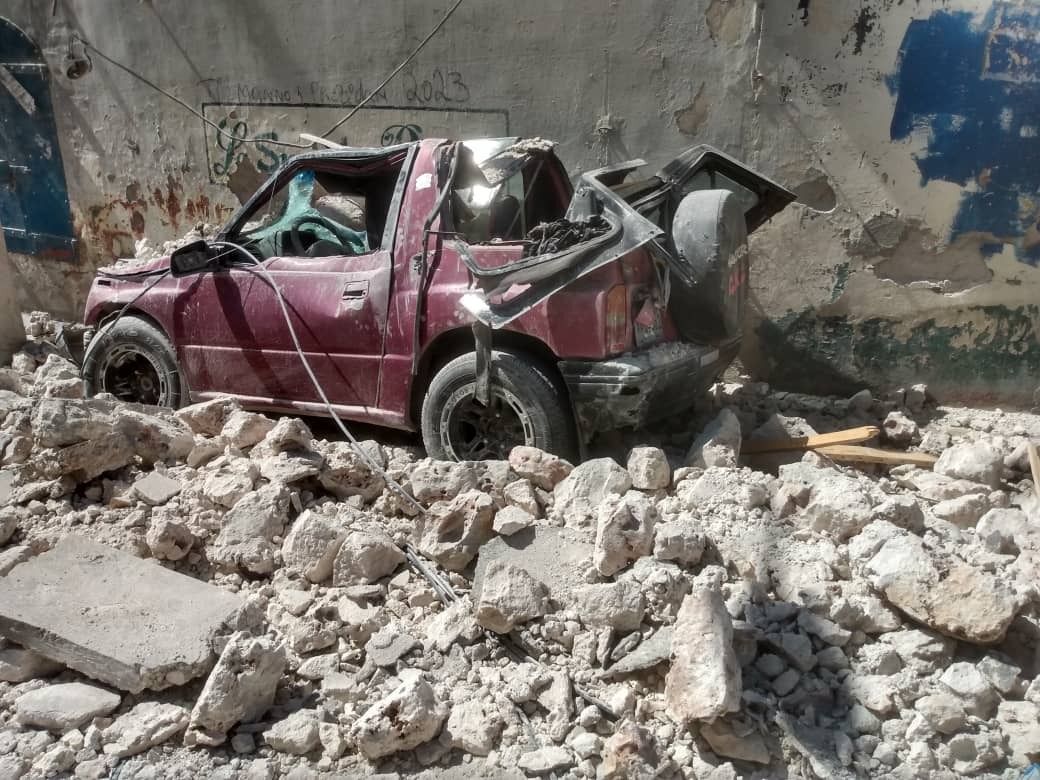 A photo shows a damaged car in the rubble after a 7.2 magnitude earthquake struck the country on August 14, 2021, in Jeremie, Haiti. 