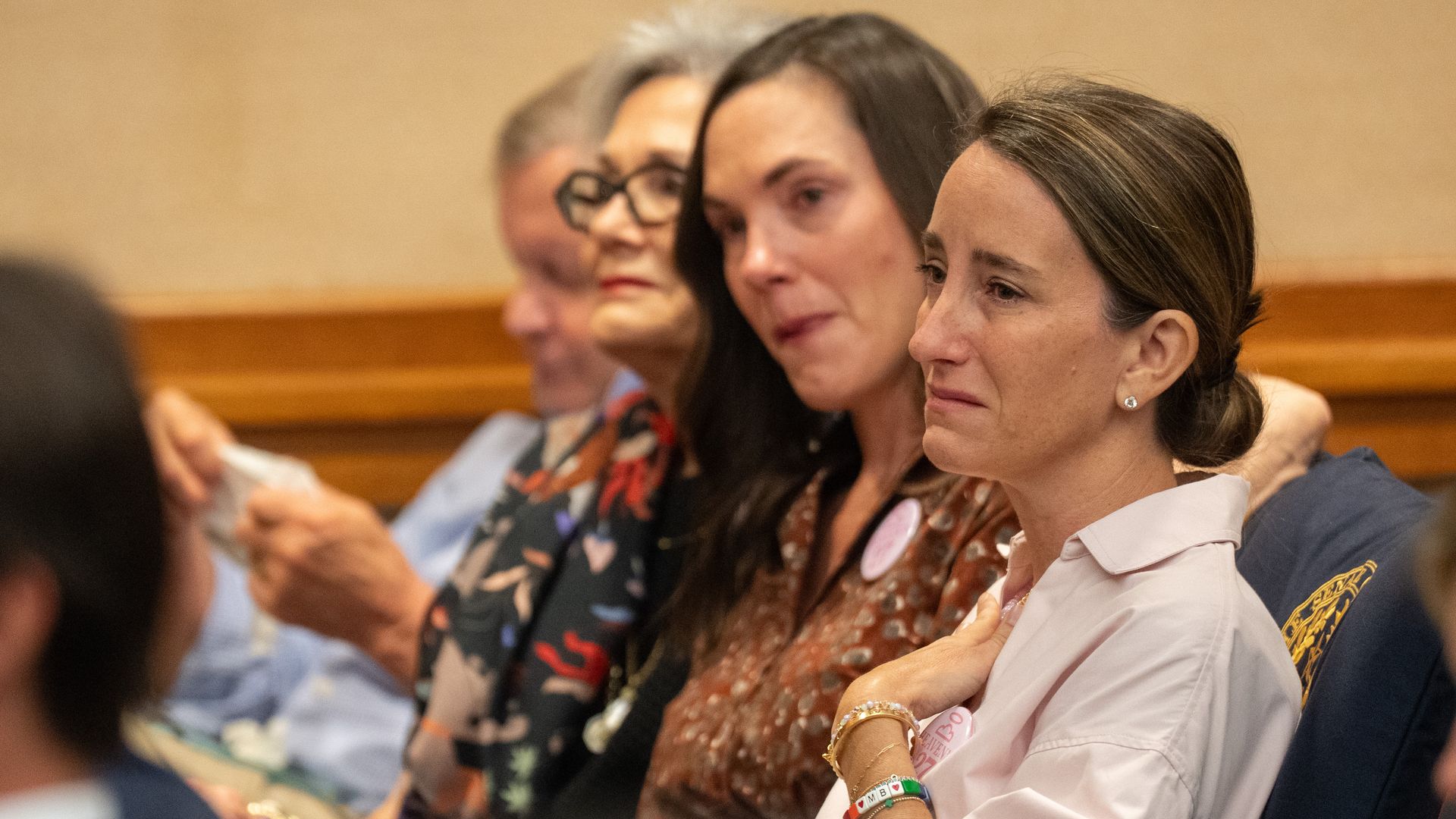 Families of Camp Mystic flooding victims have an emotional reaction to testimony in front of the Senate Disaster Preparedness and Flooding committee at the Texas Capitol last month. One woman clutches her hand to her chest.