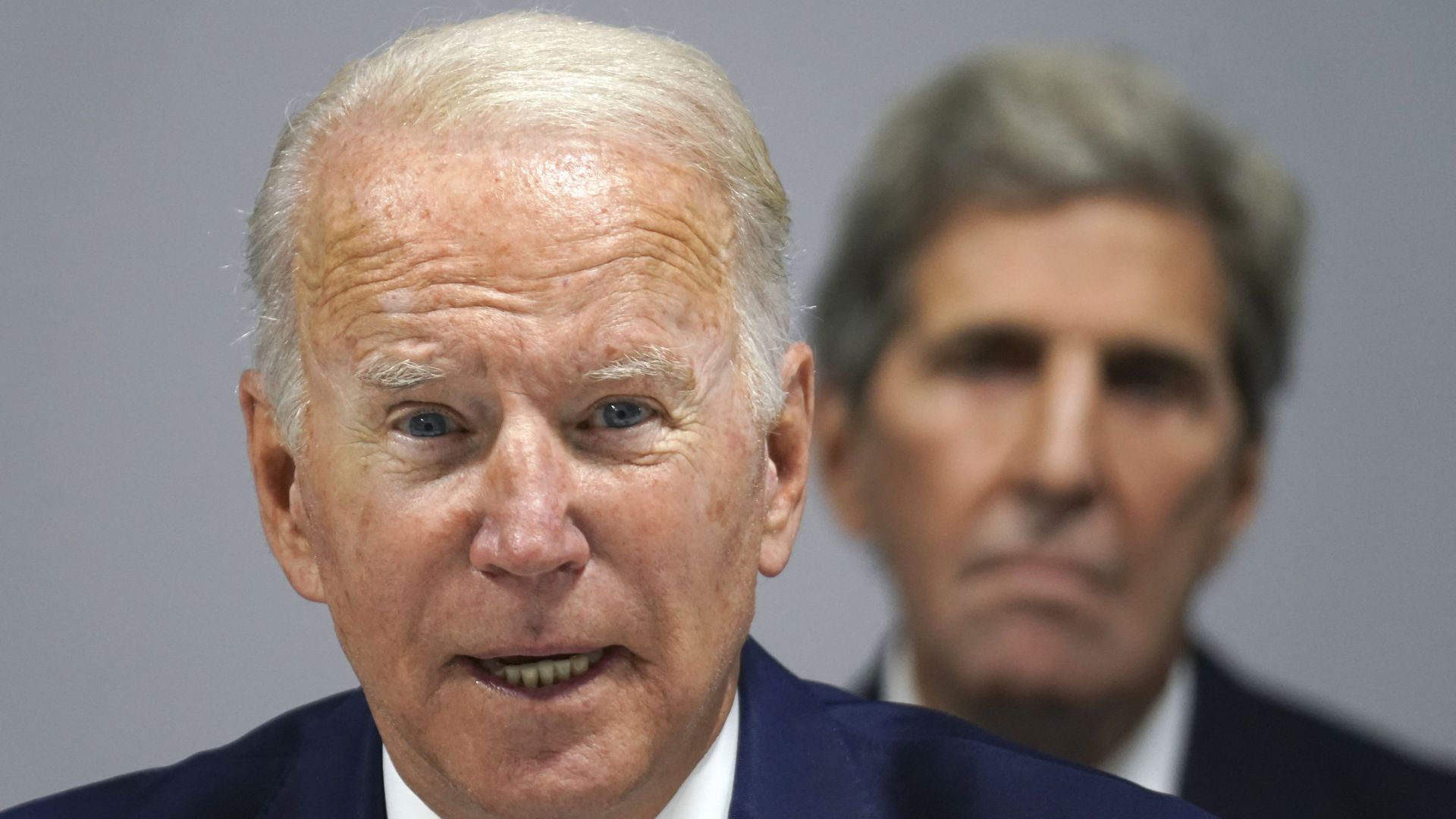 Climate envoy John Kerry is seen sitting behind President Biden as he addresses the COP26 meeting in Scotland.