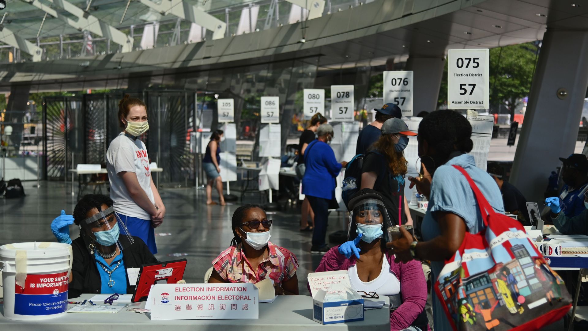 People wear face masks and practice social distancing as they prepare to vote in New York in the primary elections