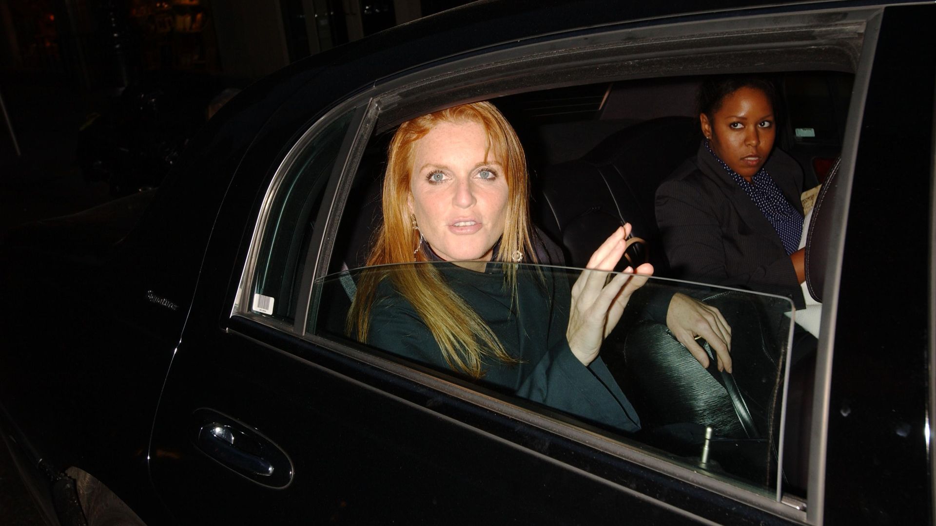 Duchess of York in a black car with her assistant in the background