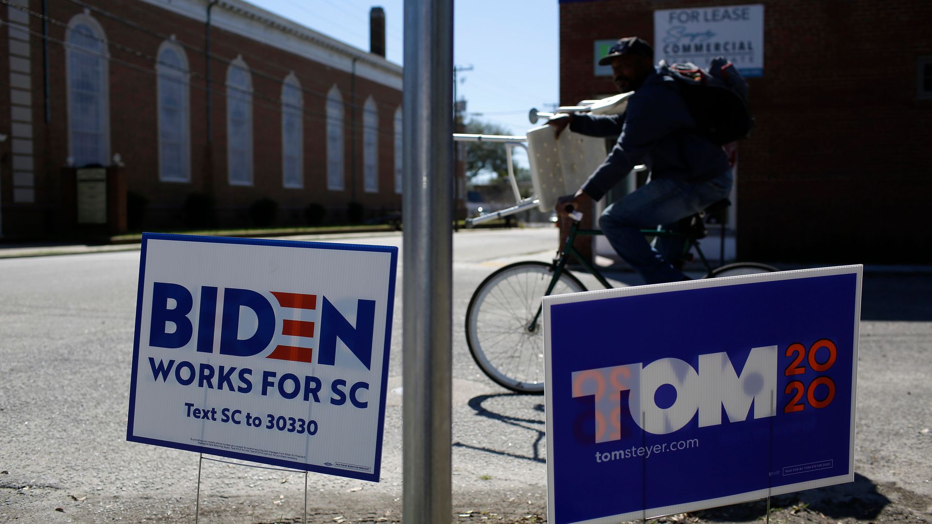 Campaign signs for Joe Biden and Tom Steyer sit in the same street corner in North Charleston, S.C.