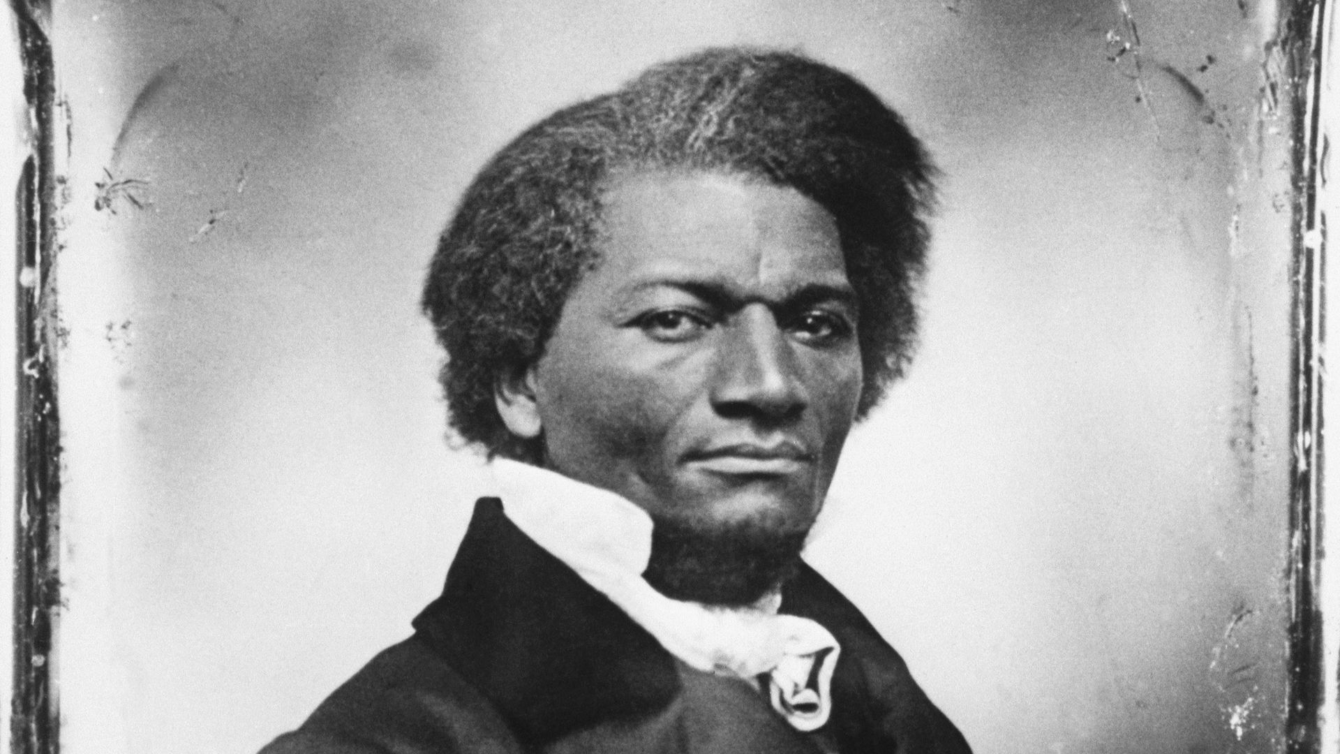American writer and abolitionist Frederick Douglass stands for a portrait while looking at the camera.