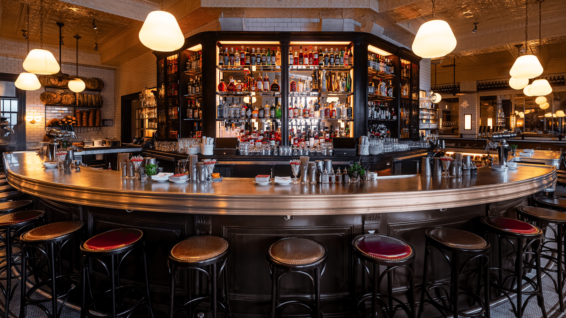 Pastis zinc bar lined with red stools and glowing lights