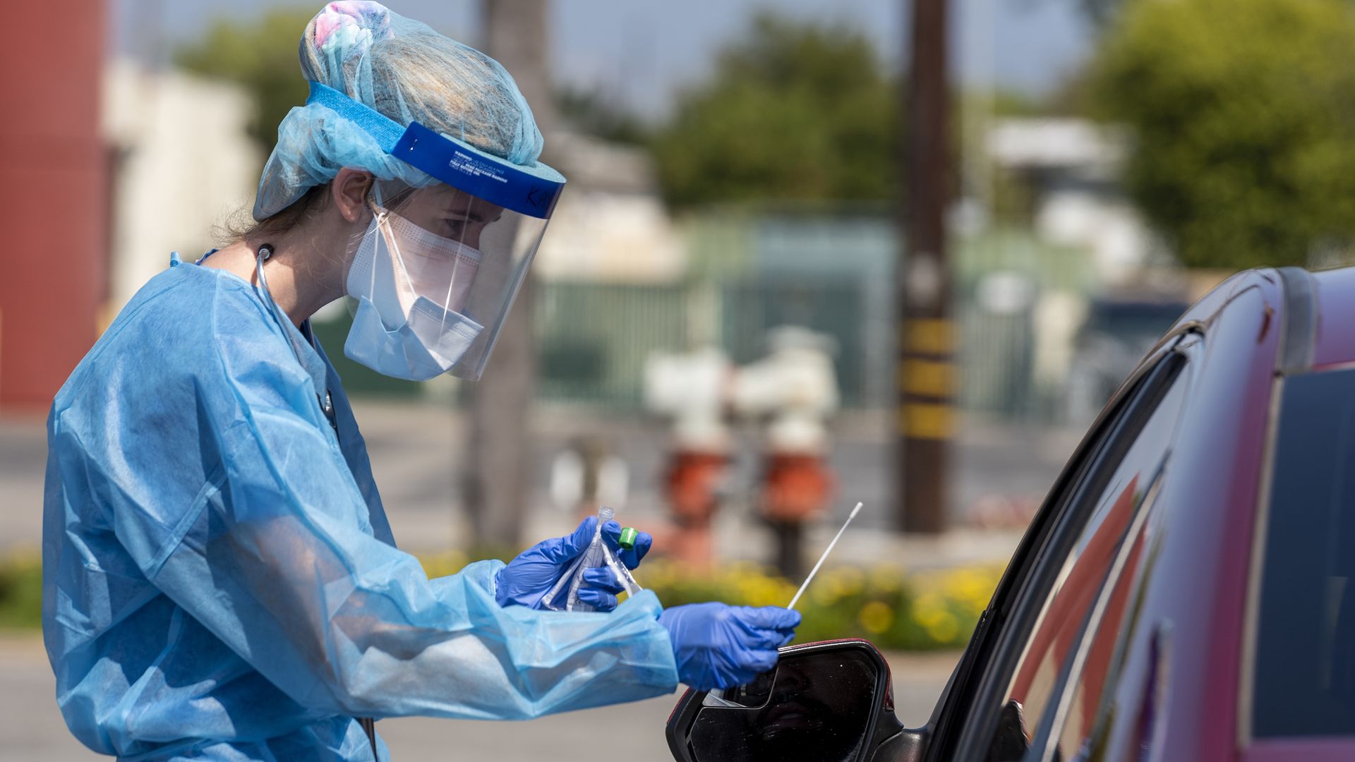 A Physician Assistant prepares to test a drive-through patient for COVID-19
