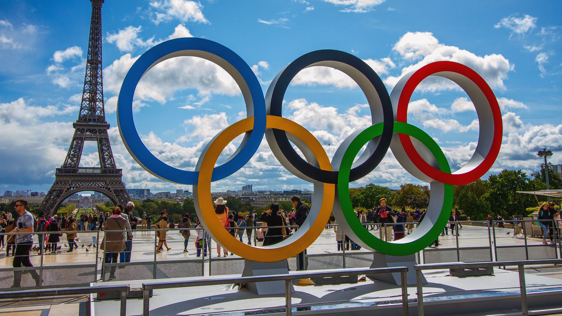 Photo of the Olympic rings set in front of the Eiffel Tower under a blue sky