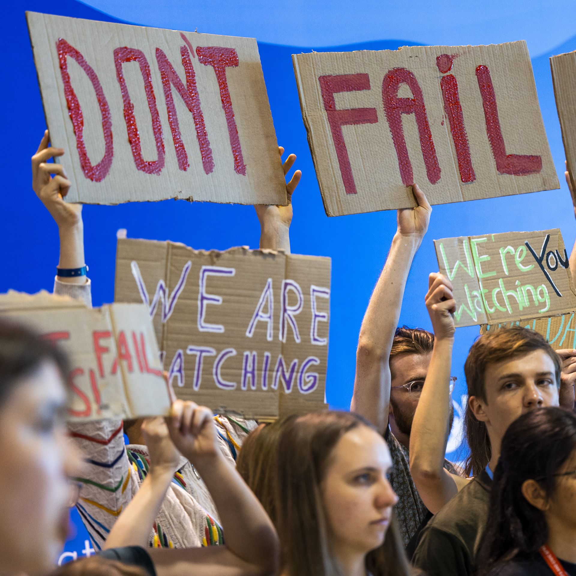 Young people hold up signs urging countries to take bold action against climate change at COP27 in Egypt.